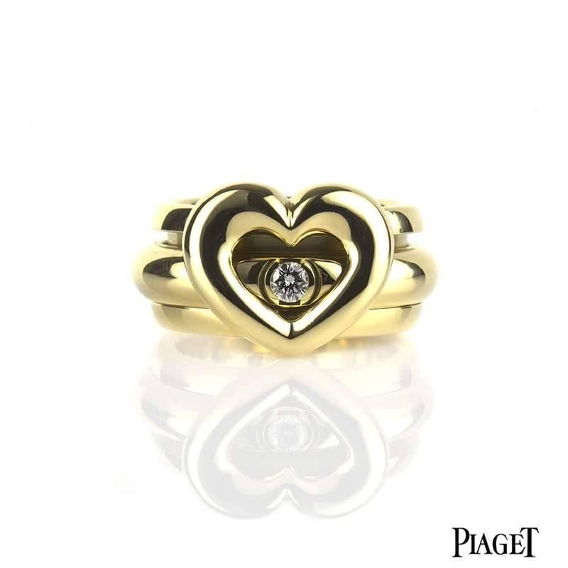 A Piaget Possession ring in 18k yellow gold set with one round brilliant cut diamond. The 0.15ct diamond is set in the inner of the two bands, which move freely around each other in perpetual movement. The open heart motif is set to the front and