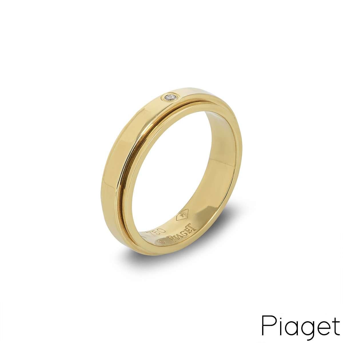 A Piaget Possession ring in 18k yellow gold, set with 1 round brilliant cut diamond. The diamond is set within the inner band, which moves freely in perpetual movement. The diamond is .14 carat and the band width is approximately 5.00mm and has a