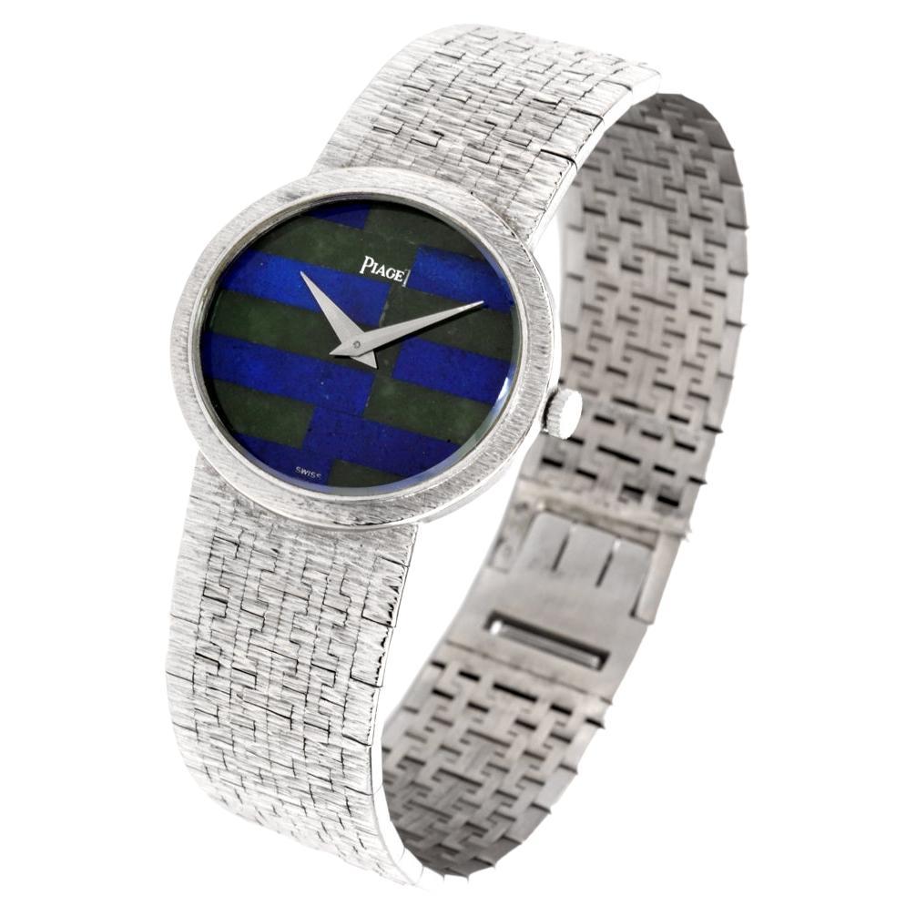 Montre Piaget Classique vintage des années 1970 en or blanc 18 carats de 27 mm avec mouvement manuel,
lunette fixe, cadran en mosaïque de jadéite et de lapis-lazuli et bracelet intégré avec fermoir à charnière.
Toutes les pièces sont d'origine