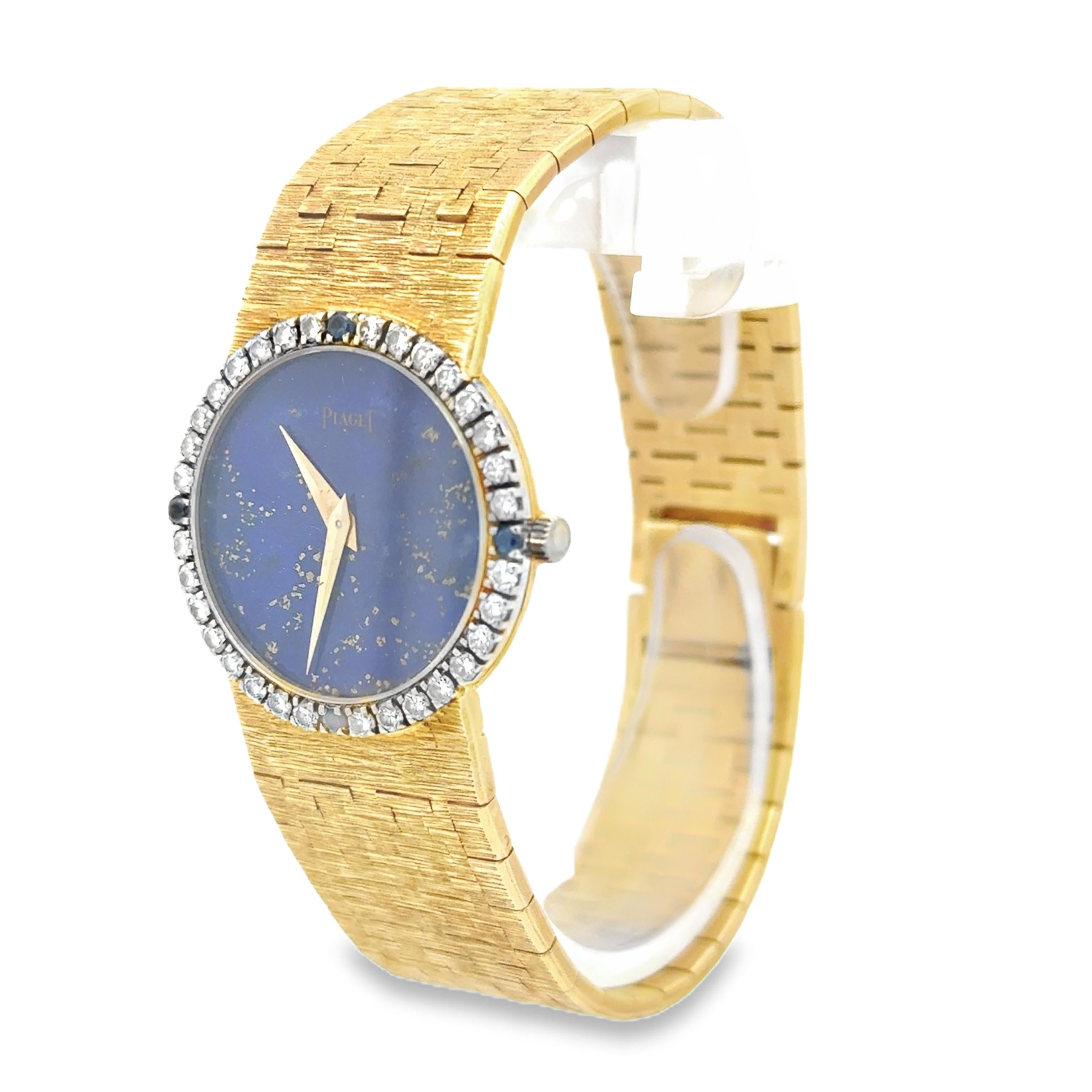 An iconic ladies' watch created by Piaget, featuring a lapis lazuli round dial surrounded by a halo of round cut diamonds with four round cut sapphires and a bracelet made of 18K yellow gold with the classic Piaget texture motif. 
