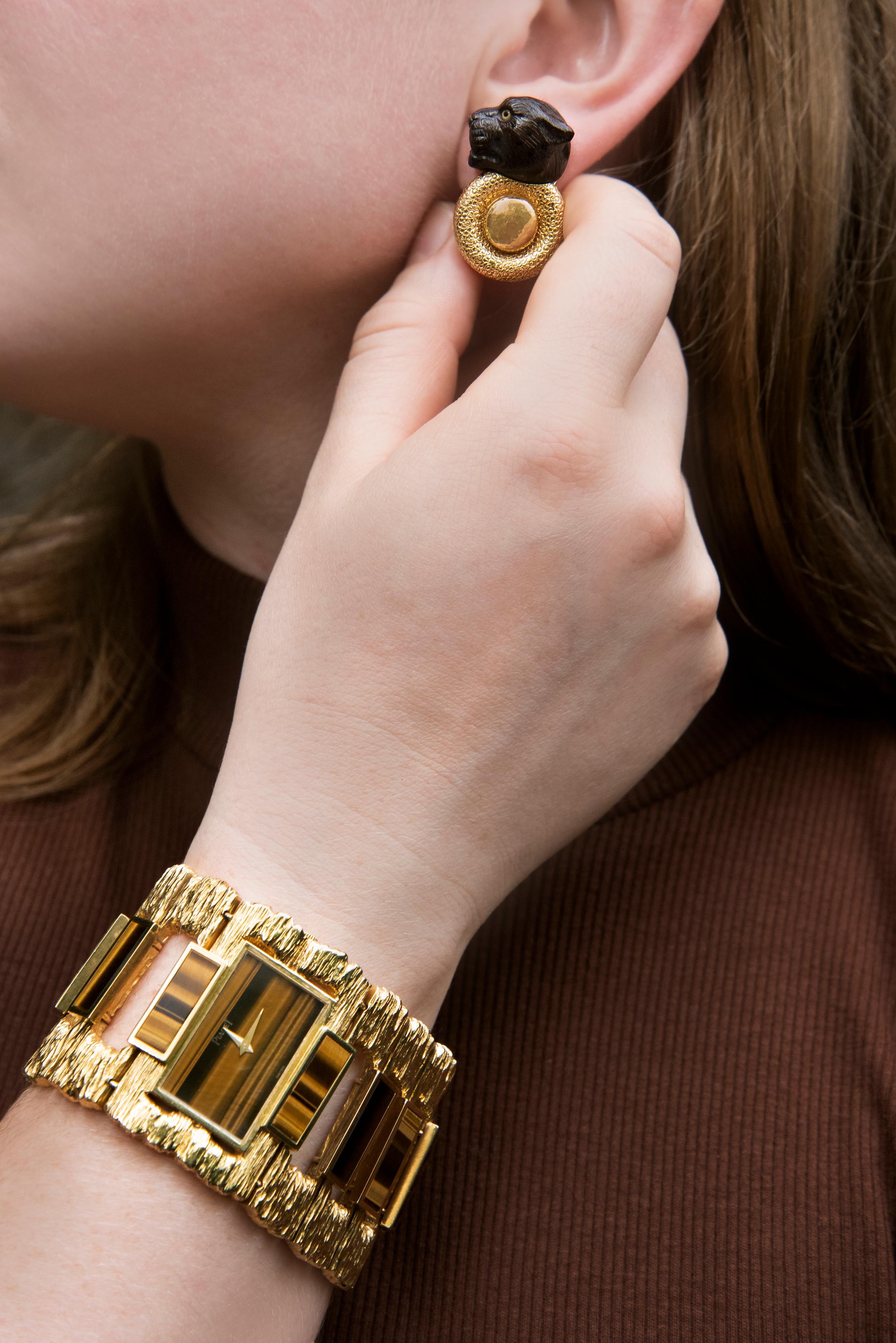 This is a rare and striking tiger’s eye and 18-karat textured yellow gold “Manchette” bracelet watch by Piaget, crafted in Switzerland in 1970. The “Manchette” collection, introduced in the late 1960s and early 1970s, was designed for a young,
