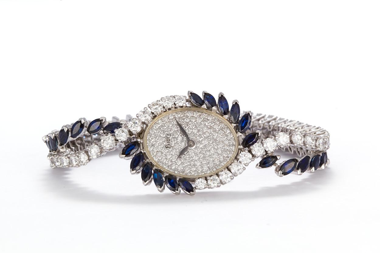 We are pleased to offer this Vintage 1950's Piaget Platinum Diamond & Sapphire Ladies Watch. This stunning watch features a tennis bracelet style design set with and estimated 6.25ctw D-F/VS1-VS2 Round Brilliant Cut Diamonds and 6.00ctw marquee cut