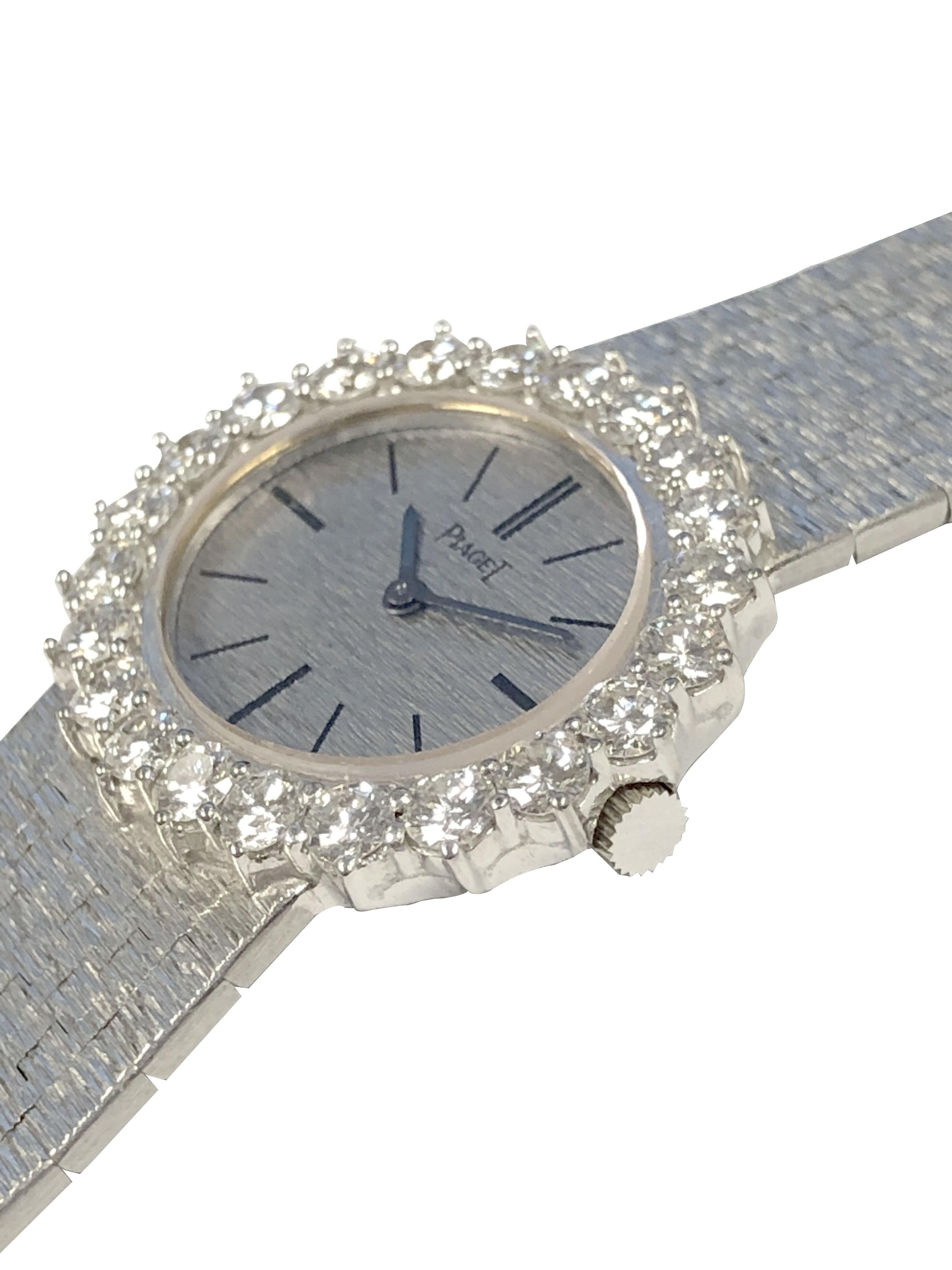 Circa 1980 Piaget Damen-Armbanduhr:: 28 X 25 M.M. 2 Stück 18K Weißgold Gehäuse:: Runde Brillantschliff Diamant Lünette insgesamt 1::50 Karat. 17 Juwelen mechanisch:: Handaufzug Bewegung:: Gold strukturierte Zifferblatt:: 5/8 Zoll breit strukturierte