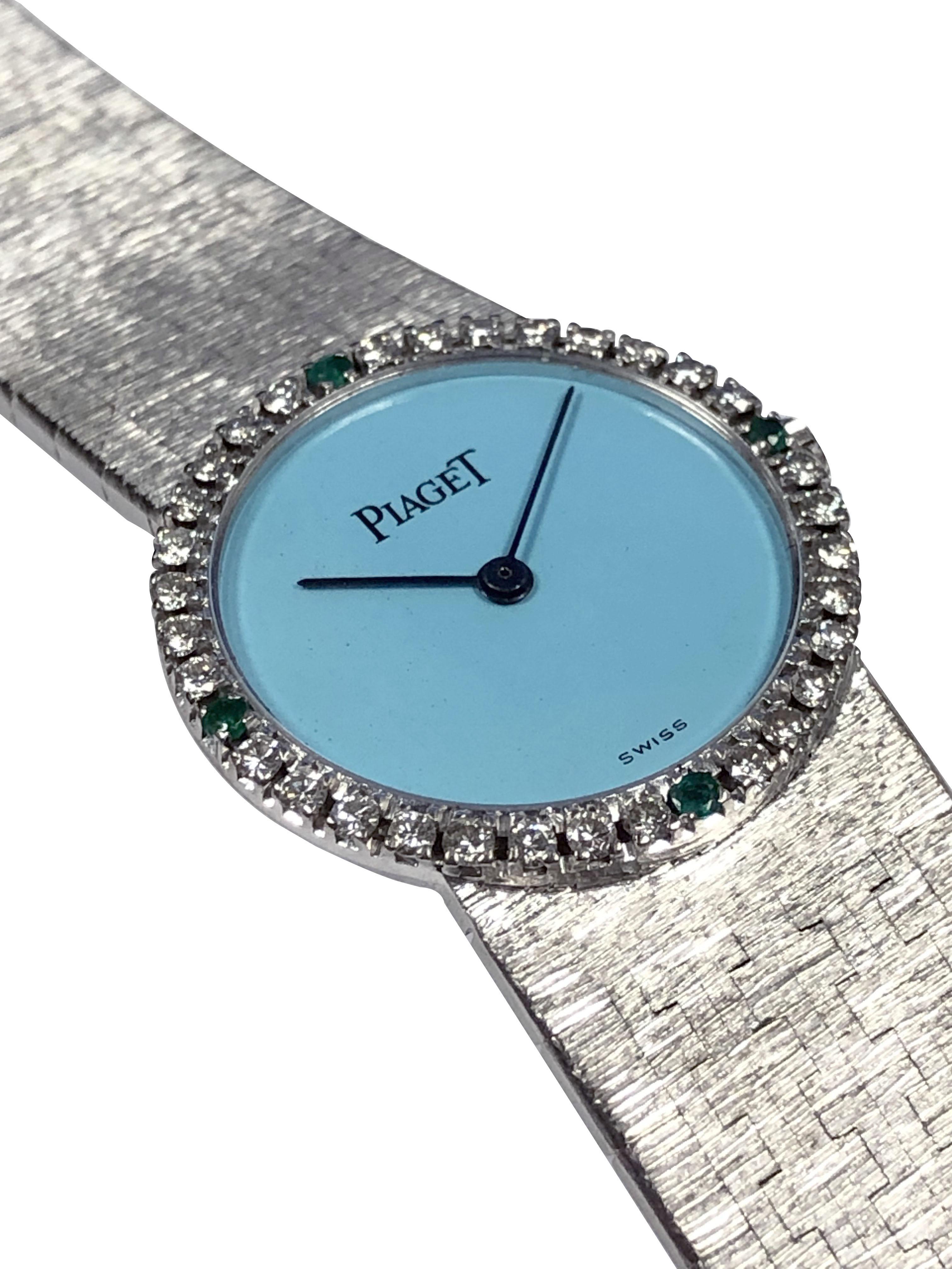 Circa 1970 Piaget Wrist Watch, 24 M.M. 18k White Gold 2 piece case with a Diamond and Emerald set bezel. Mechanical, Manual wind movement, Turquoise Dial. 5/8 inch wide Integrated mesh link textured bracelet.  Wrist size 6 1/2 inches. Recently
