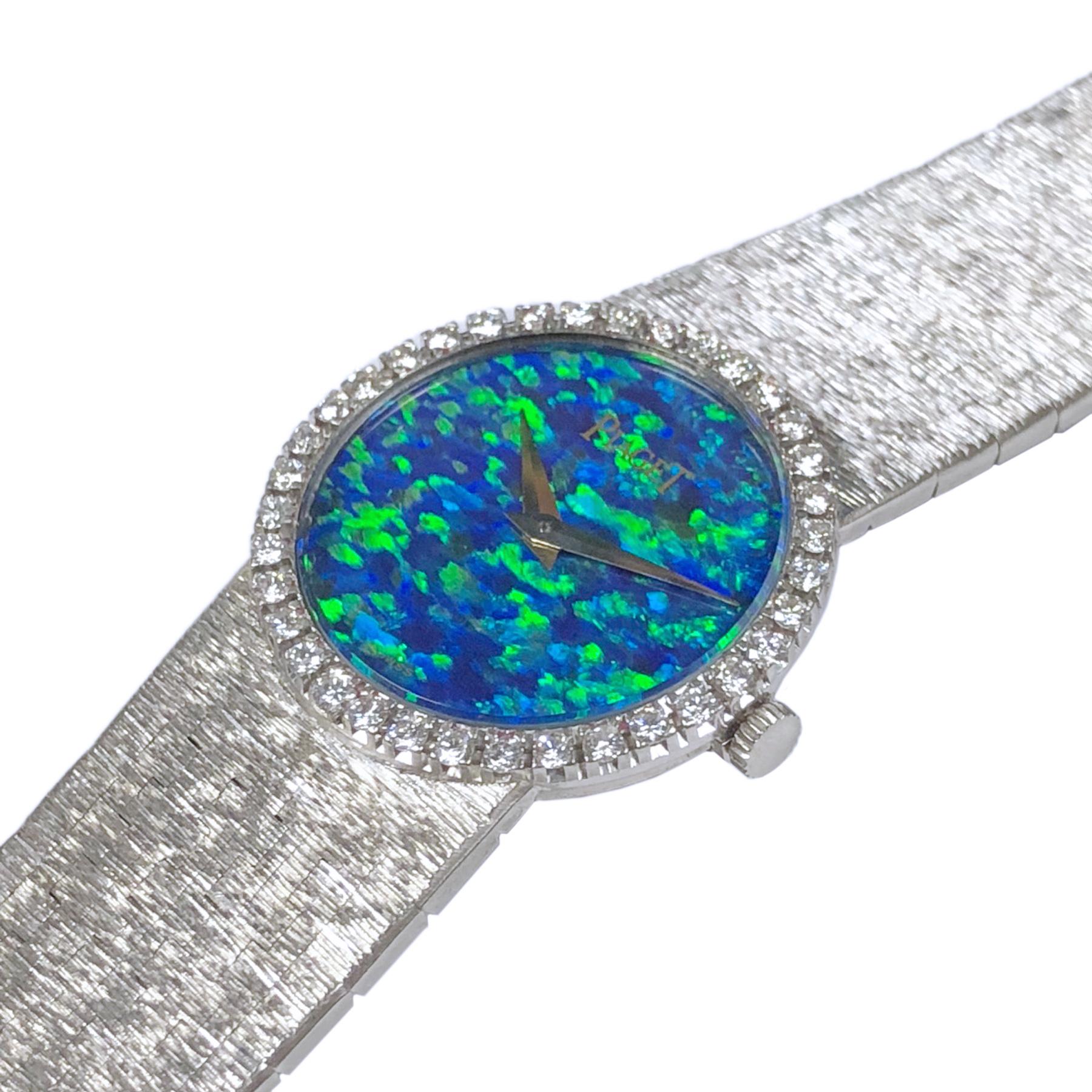 Circa 1970s Piaget ladies Wrist watch, 24 MM 18K White Gold case with Piaget factory set Diamond bezel of Round Brilliant cuts totaling approximately 1 carat. Opal Dial of Fiery color Blues, greens Reds. 17 Jewel mechanical, manual wind movement.