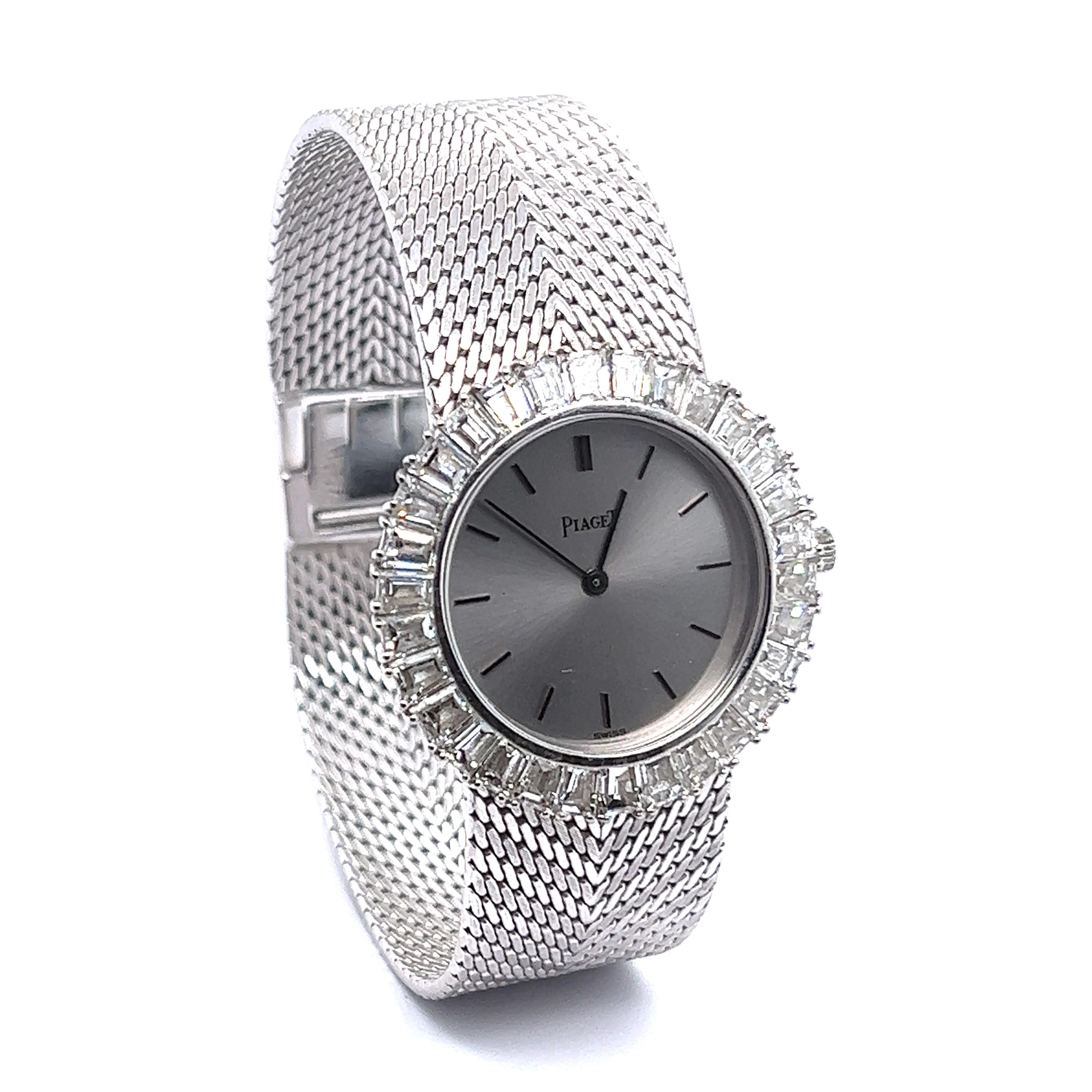 Fine Piaget lady’s cocktail watch crafted in 18 Karat white gold. The bezel is set with an entourage consisting of 30 tapered baguette-cut diamonds totalling approximate 5.50 ct. Fine white gold milanaise bracelet with jewellery style clasp in 18