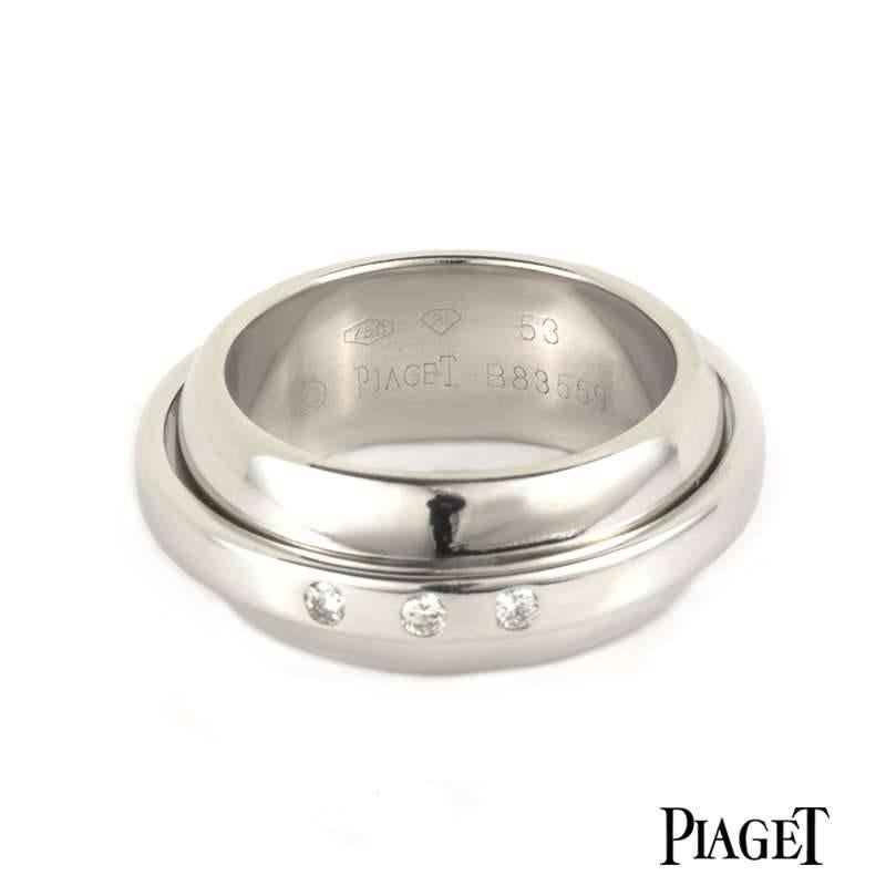 An 18k white gold Possession ring by Piaget. The 8mm band has a 4mm band pivoting the centre which is set to the front with 3 diamonds. The ring is UK size 7, EU size 55 and UK size O and has a gross weight of 18.61 grams. 

The ring comes complete