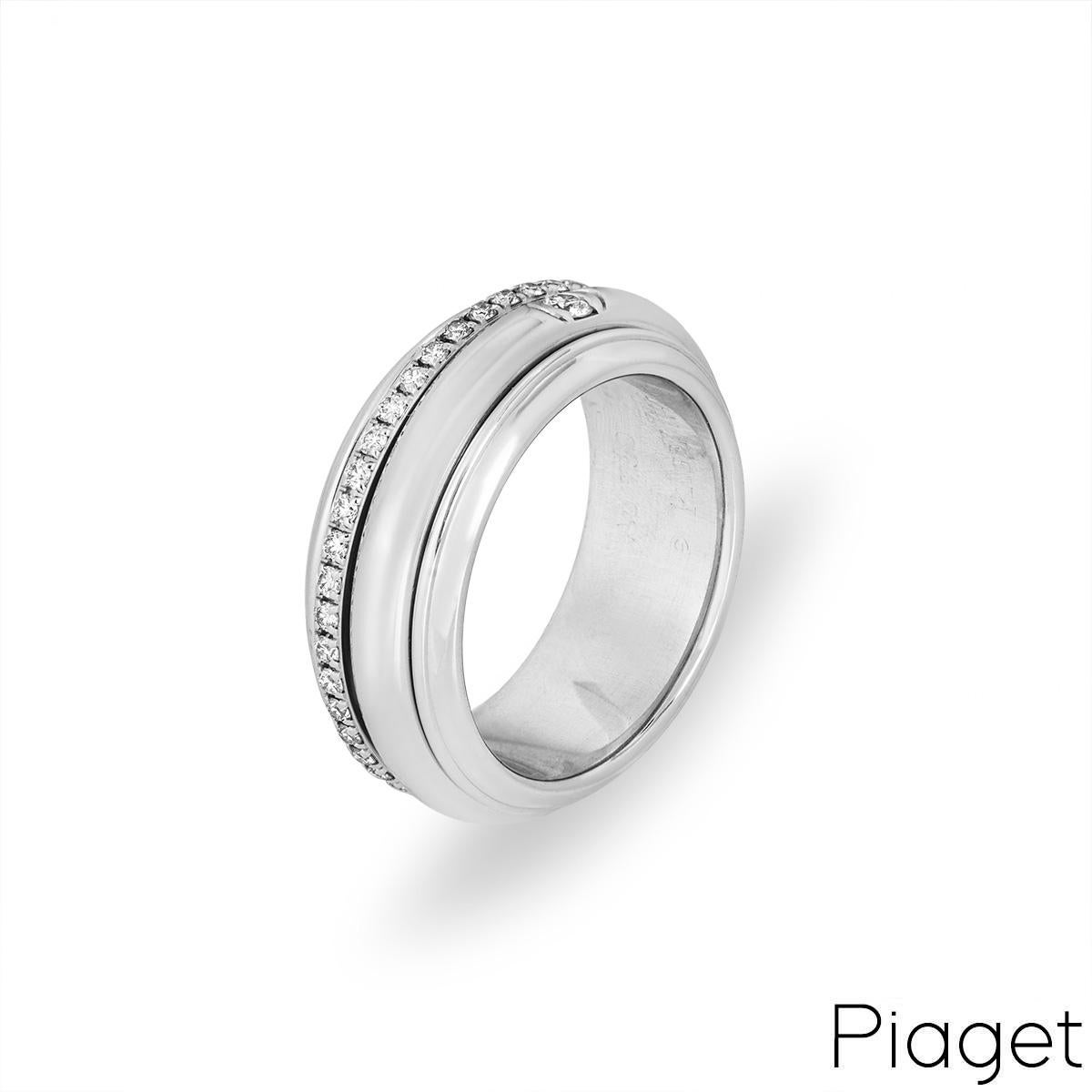 An 18k white gold diamond set ring by Piaget from the Possession collection. The 8mm band is set with two spinning bands between bevelled edges. The first band is half bezel set with a single round brilliant cut diamond and the second is pave set