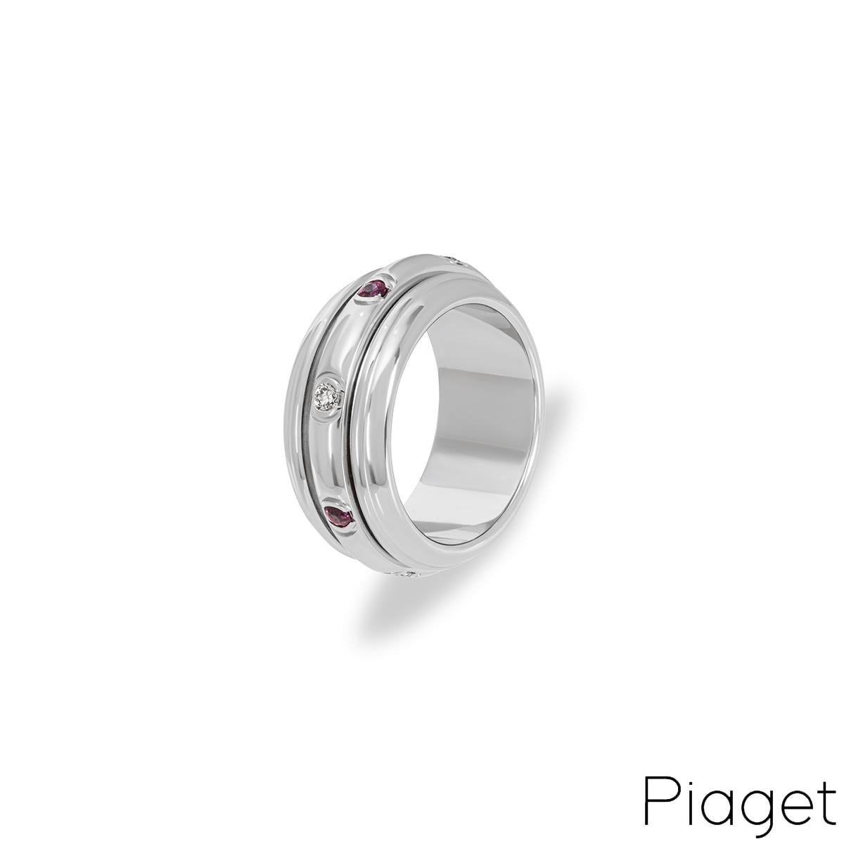 An 18k white gold ruby and diamond set ring by Piaget from the Possession collection. The ring features a freely moving centre band set with rubies and diamonds. There are four tension set rubies with an approximate total weight of 0.15ct and
