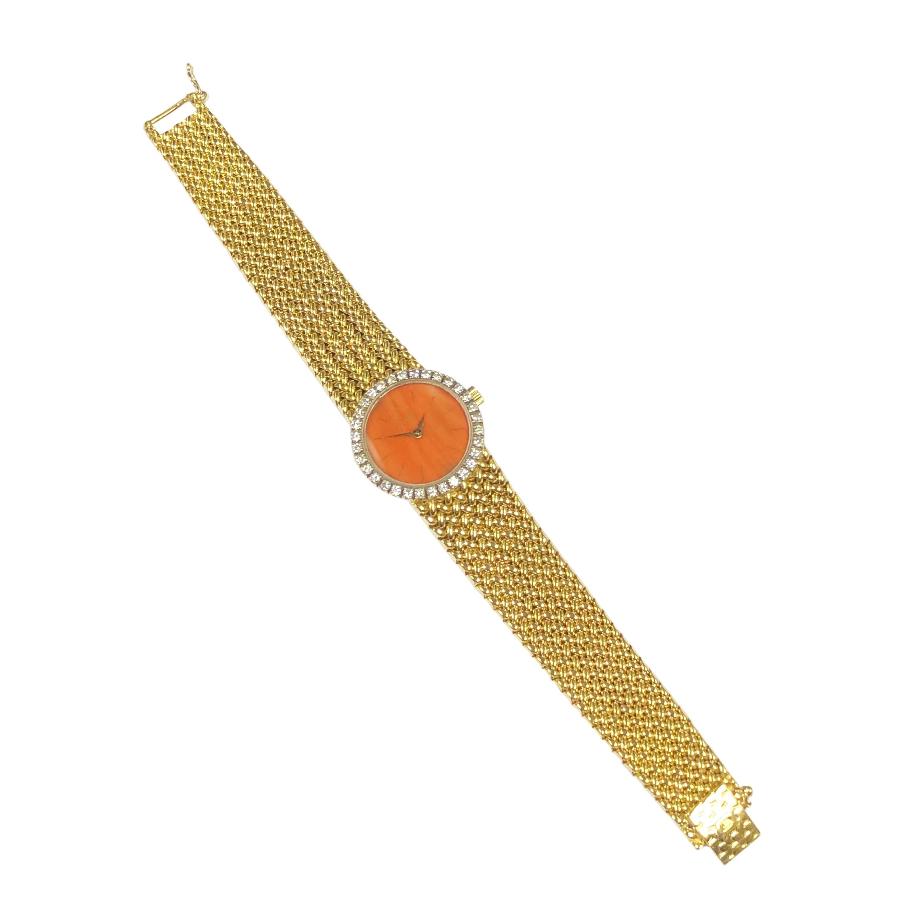 Circa 1980 Piaget Ladies Wrist Watch, 22 MM 18K Yellow Gold case, Piaget Factory set Bezel of Round Brilliant cut Diamonds totaling 1 Carat. Coral Dial, 17 Jewel mechanical, manual wind movement. 5/8 inch wide Piaget signed mesh link bracelet. Total