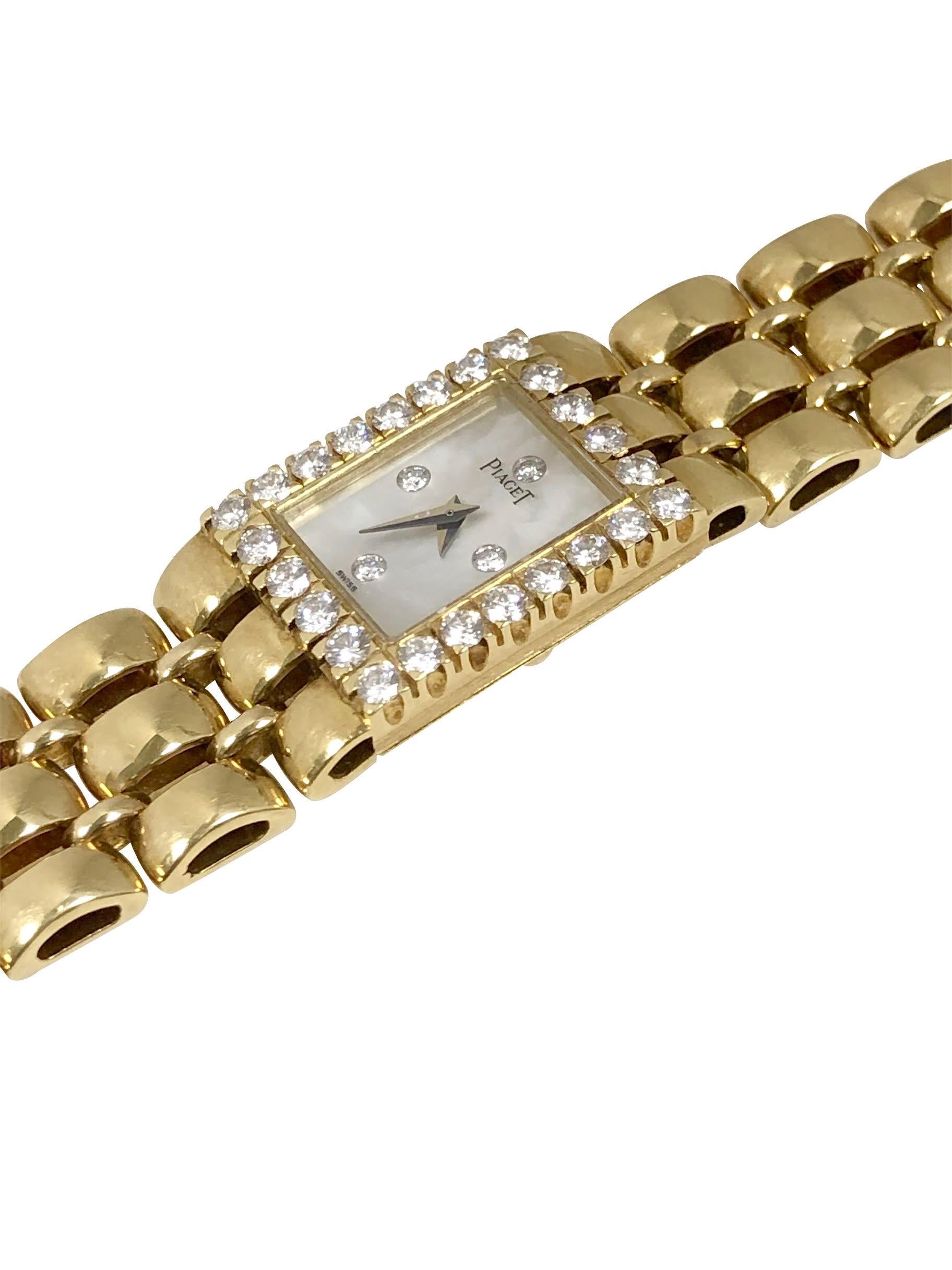 Circa 1990 Piaget Ladies Wrist Watch 18 X 14 M.M. 2 piece case, with a Bezel of fine White Round brilliant cut Diamonds totaling 1 Carat. Quartz Movement with Back set feature, Mother of Pearl Dial with Diamond set markers. 1/2 inch wide oval link