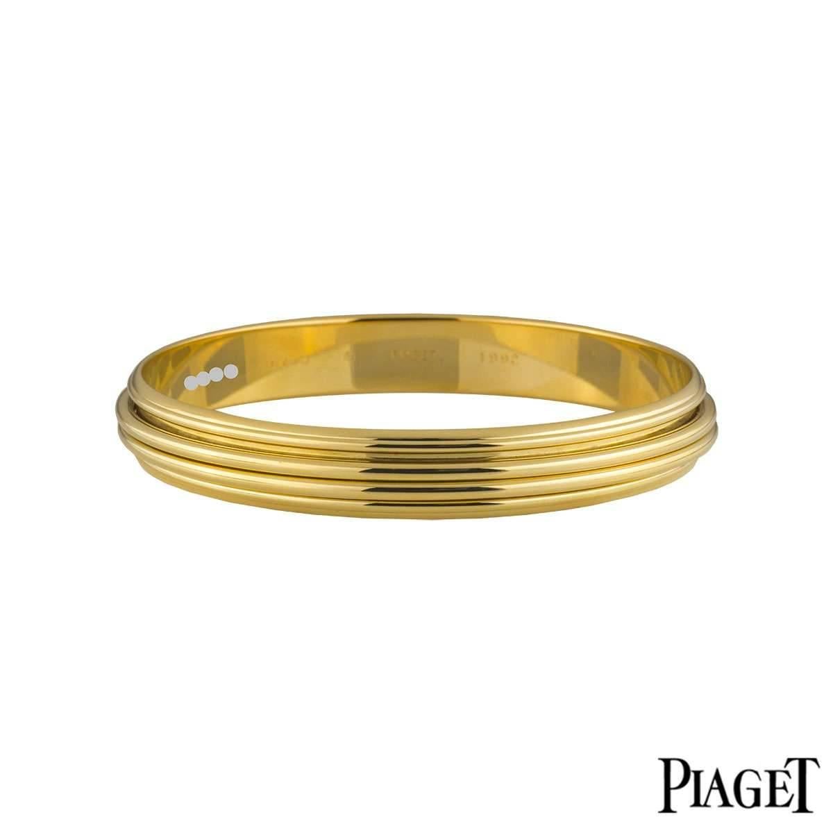 An 18k yellow gold bangle from the Possession collection by Piaget. The bangle has fluted boarders containing 2 spinning gold rings in the centre. The bangle measures 11mm in width and is 8.25 inches in circumference. The bangle has a gross weight