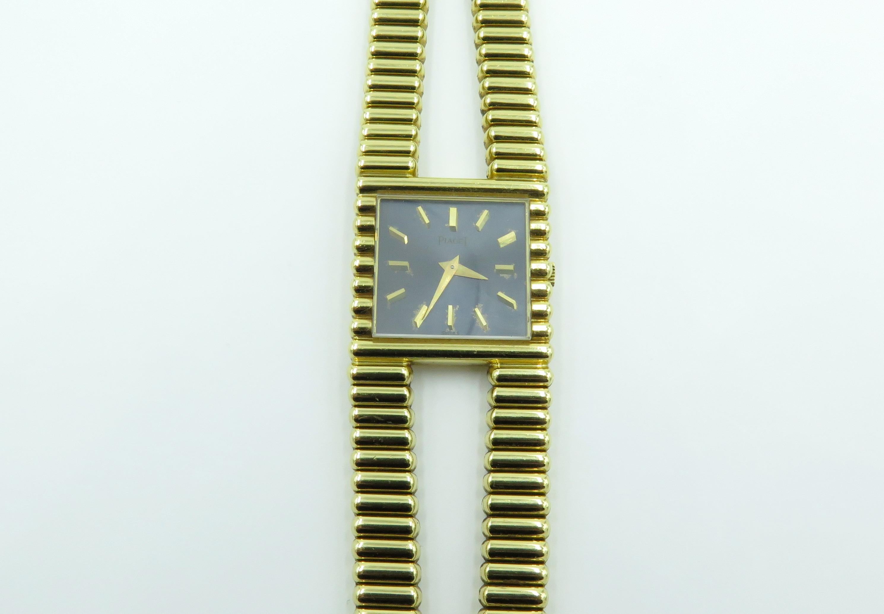 An 18 karat yellow gold watch. Piaget. Circa 1970. 25mm, Of mechanical movement, the dark gray square dial with applied gold tone baton numerals, joined by a double row rigged gold bracelet.  Length is approximately 7 1/4 inches, gross weight