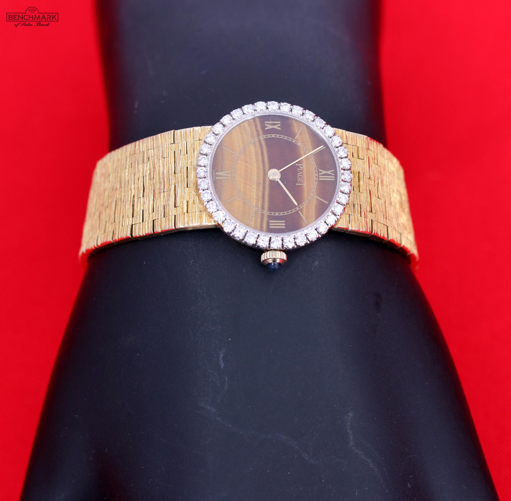 An 18K yellow gold Piaget watch centered around a tiger's eye dial with gold Roman numerals. Around the case is a white gold bezel set with 34 round brilliant cut diamonds weighing approximately 0.85ct of overall F/G color and VVS1/VVS2 clarity.