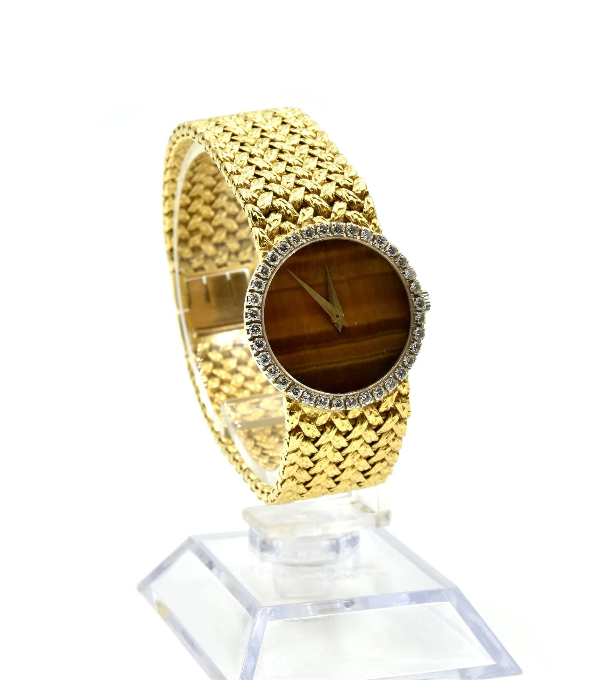 Movement: mechanical
Function: hours, minutes
Case: round 24mm 18k yellow gold case with diamond bezel, plastic protective crystal, winding crown
Diamonds: 36 round brilliant cuts = 1.00 carat total weight
Dial: tigers eye dial with gold hands
Band: