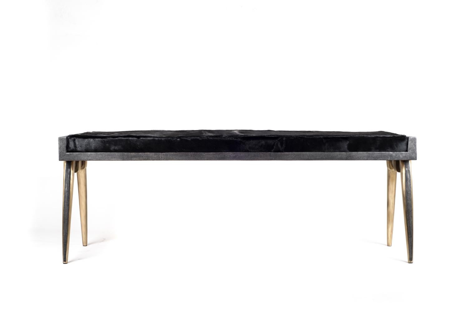 The pianist bench has subtle and elegant details on its legs, with a mixture of bronze and coal black shagreen inlay. The bronze-patina brass overlap on both sides adds another unique element to piece. The black horsehair covered cushion is