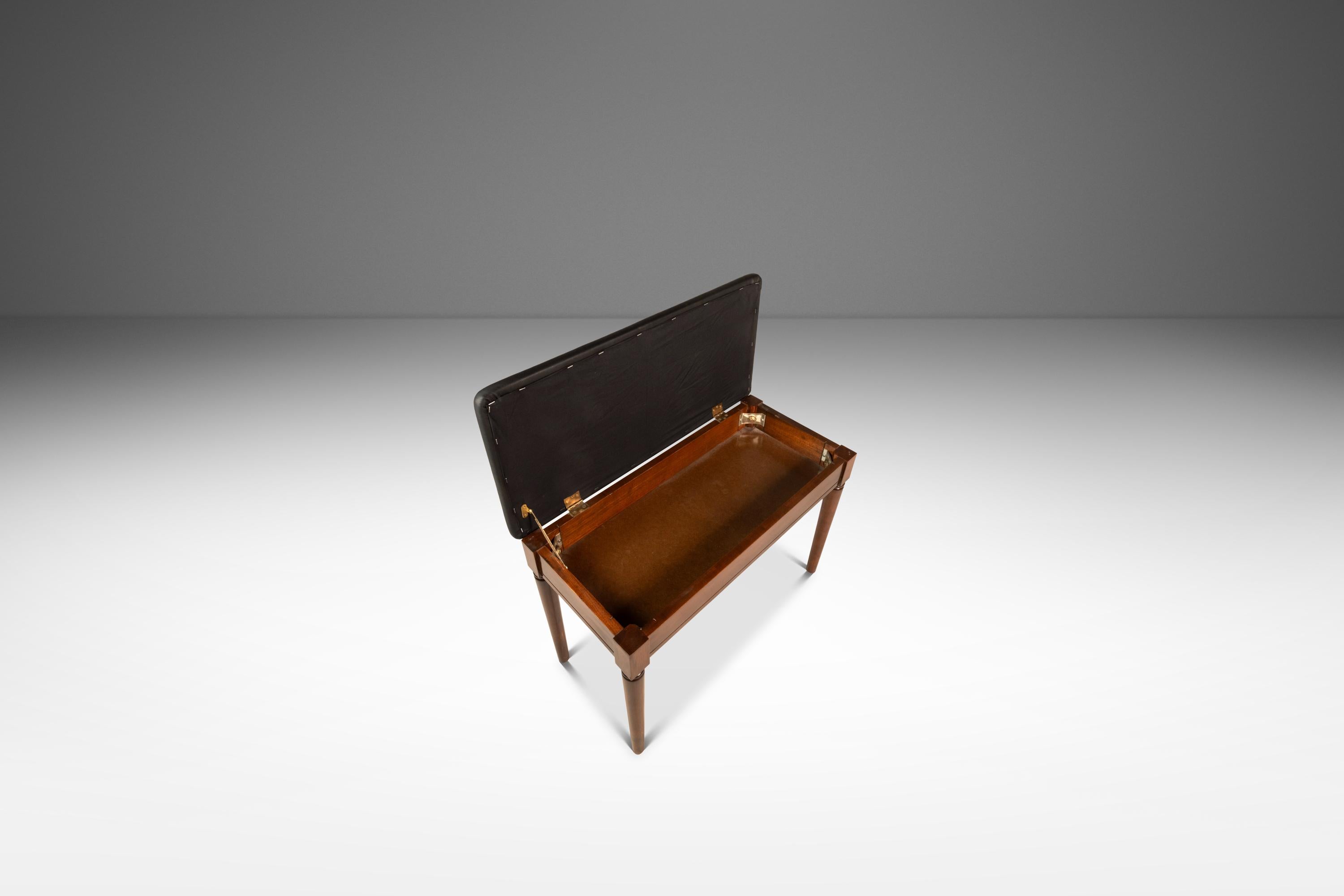 The perfect blend of minimal and functional this splendid Mid-Century Modern piano bench, hand-made by the Manual Arts Furniture Co. , is the perfect pairing to a Baldwin Acrosonic Piano. The bench has ample storage that sits under a