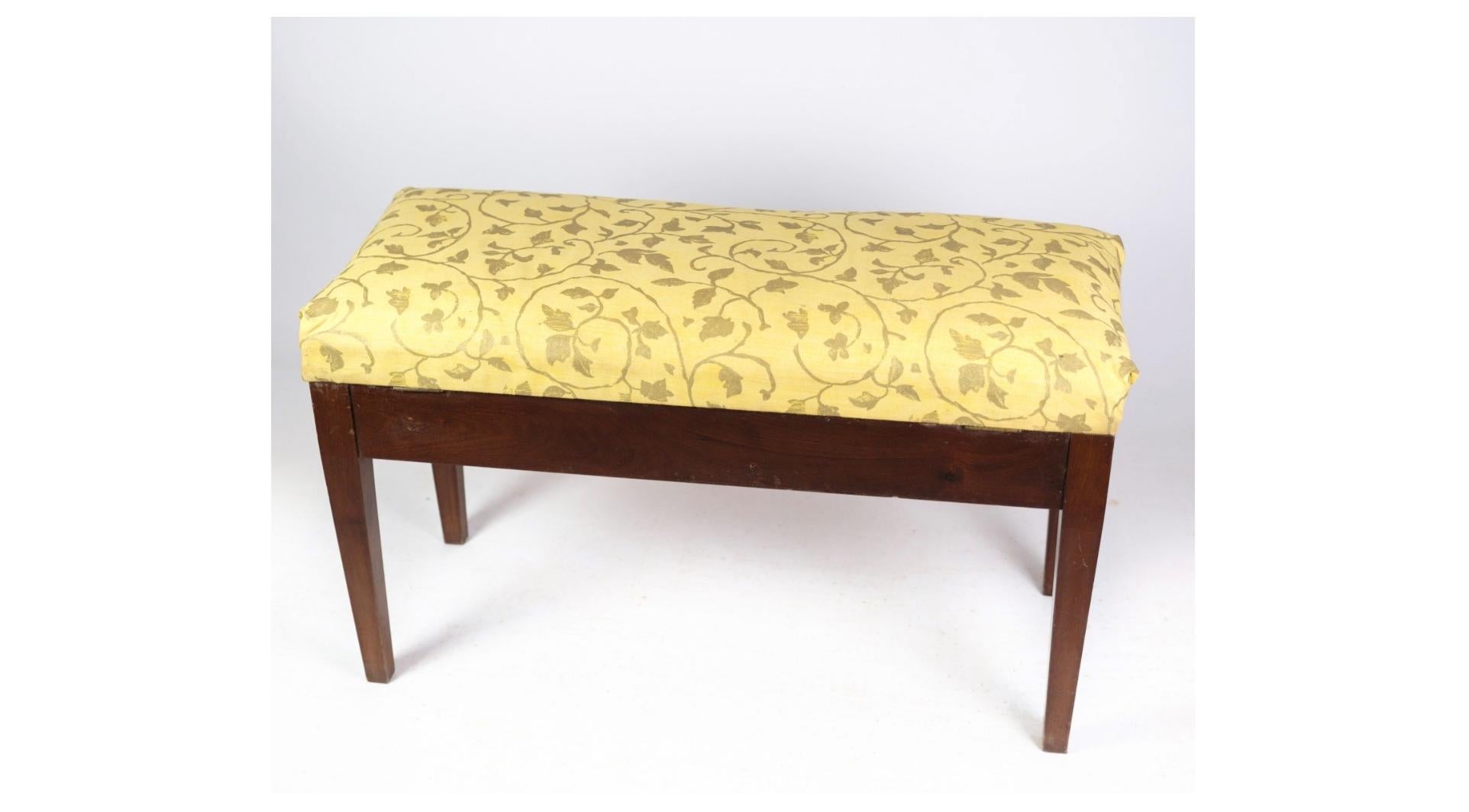 The piano bench or stool in mahogany with light floral fabric from around 1910 is a charming and elegant piece of furniture that exudes vintage charm and sophistication. Crafted from rich mahogany wood, known for its durability and warm tones, this