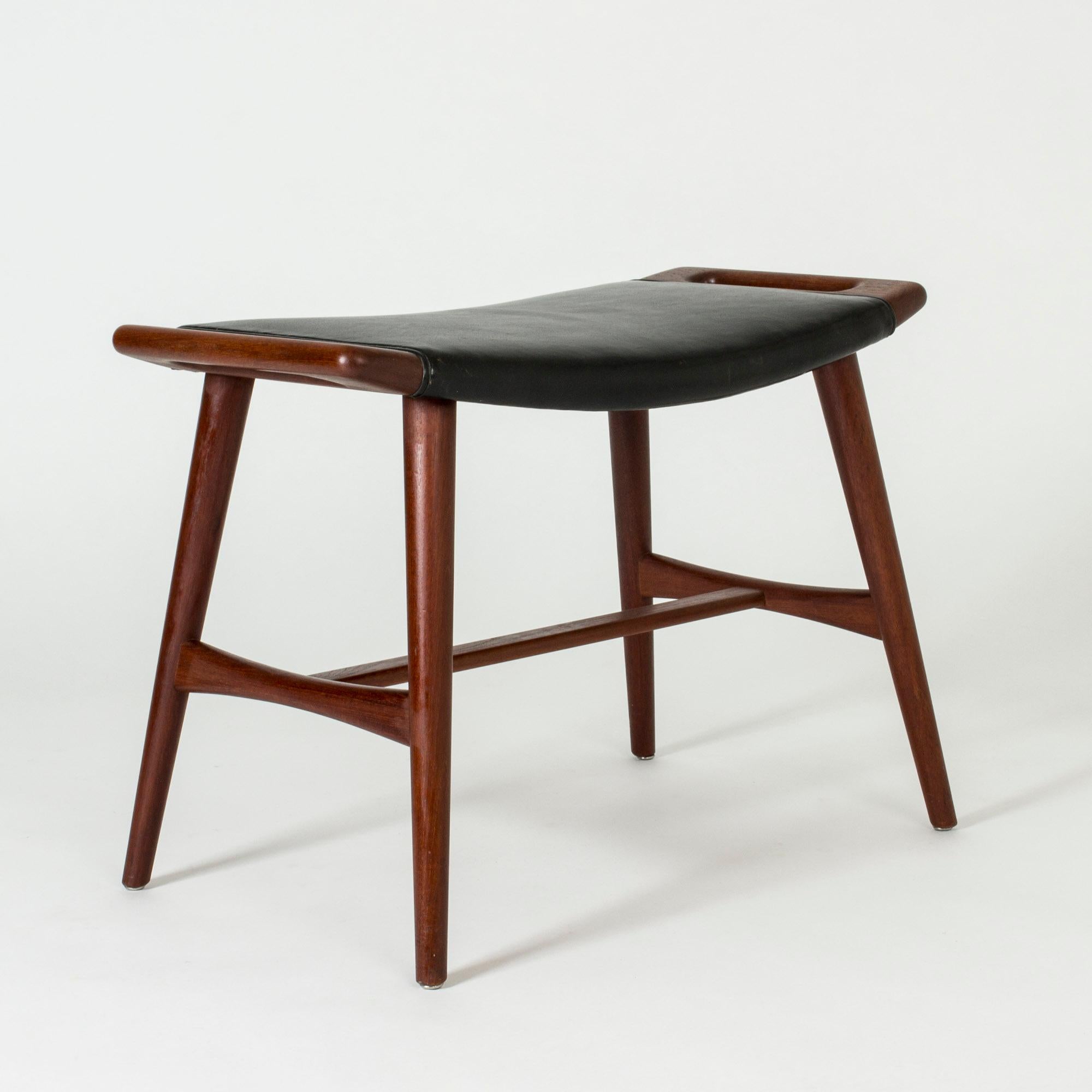 Rare piano stool by Hans J. Wegner, made from teak with original black leather upholstery. Beautiful sculpted handles on the sides of the seat, great condition.