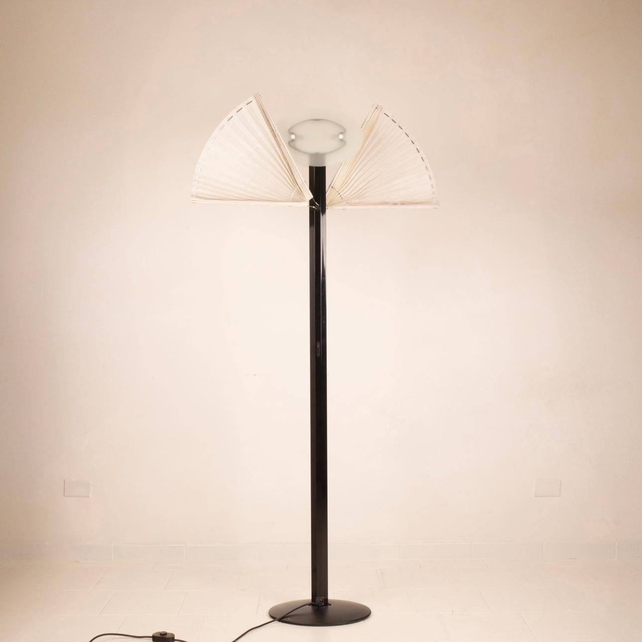 Superbe lampadaire conçu par Afra & Tobia Scarpa pour la société italienne Flos dans les années 1980, modèle Butterfly.
Tige en aluminium émaillé noir, surmontée d'une lampe halogène à gradation, une paire de vitres en verre gravé entoure et protège