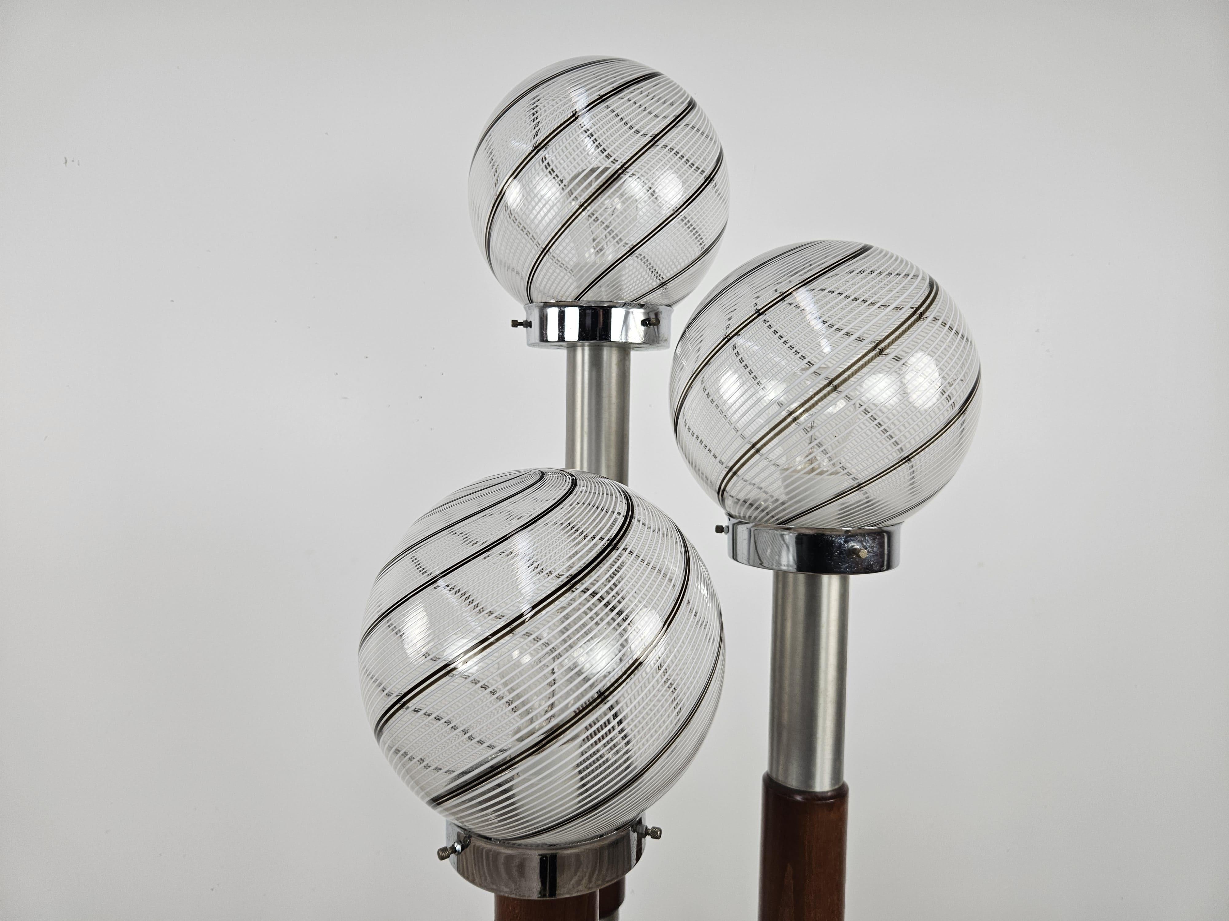 Elegant 1970s floor lamp with wood and steel frame and three points of light in Murano glass with Swirl spiral effect.

Note the floor lamp while it is lit as it makes any type of modern or antique room cozy and warm, it is perfectly matched to any
