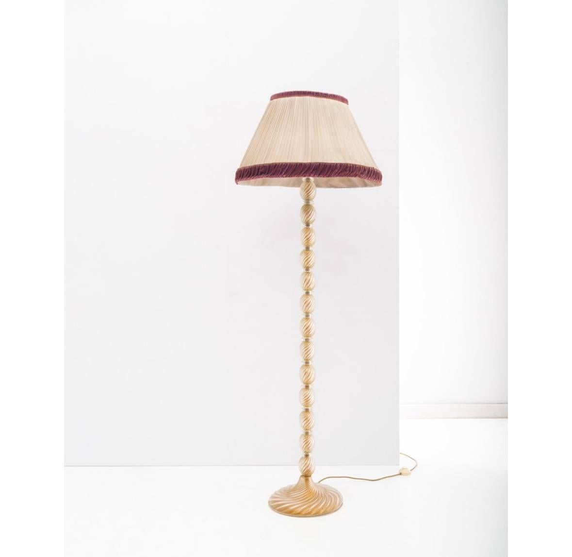 Esta elegante lámpara de pie de cristal de Murano, diseñada por el célebre diseñador Ercole Barovier para Seguso en la década de 1950, encarna la sofisticación y el esplendor de la artesanía veneciana de mediados de siglo. Su cristalería distintiva