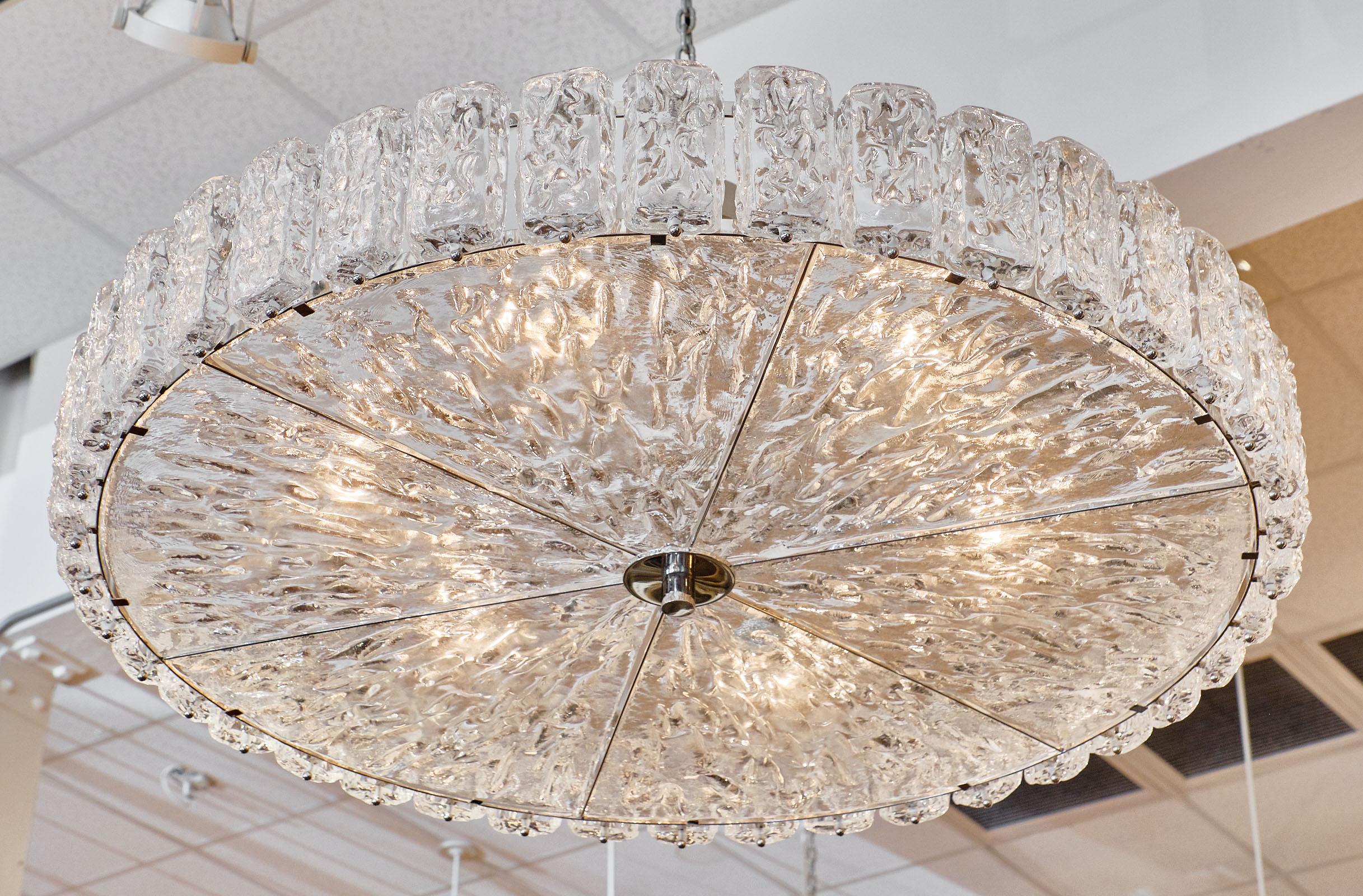 Murano glass “Piastre” chandelier with hand blown textured glass components. We love the ice effect of the pieces! This fixture has been newly wired to fit US standards. The current height from ceiling is 15.625”.

This piece is currently located at