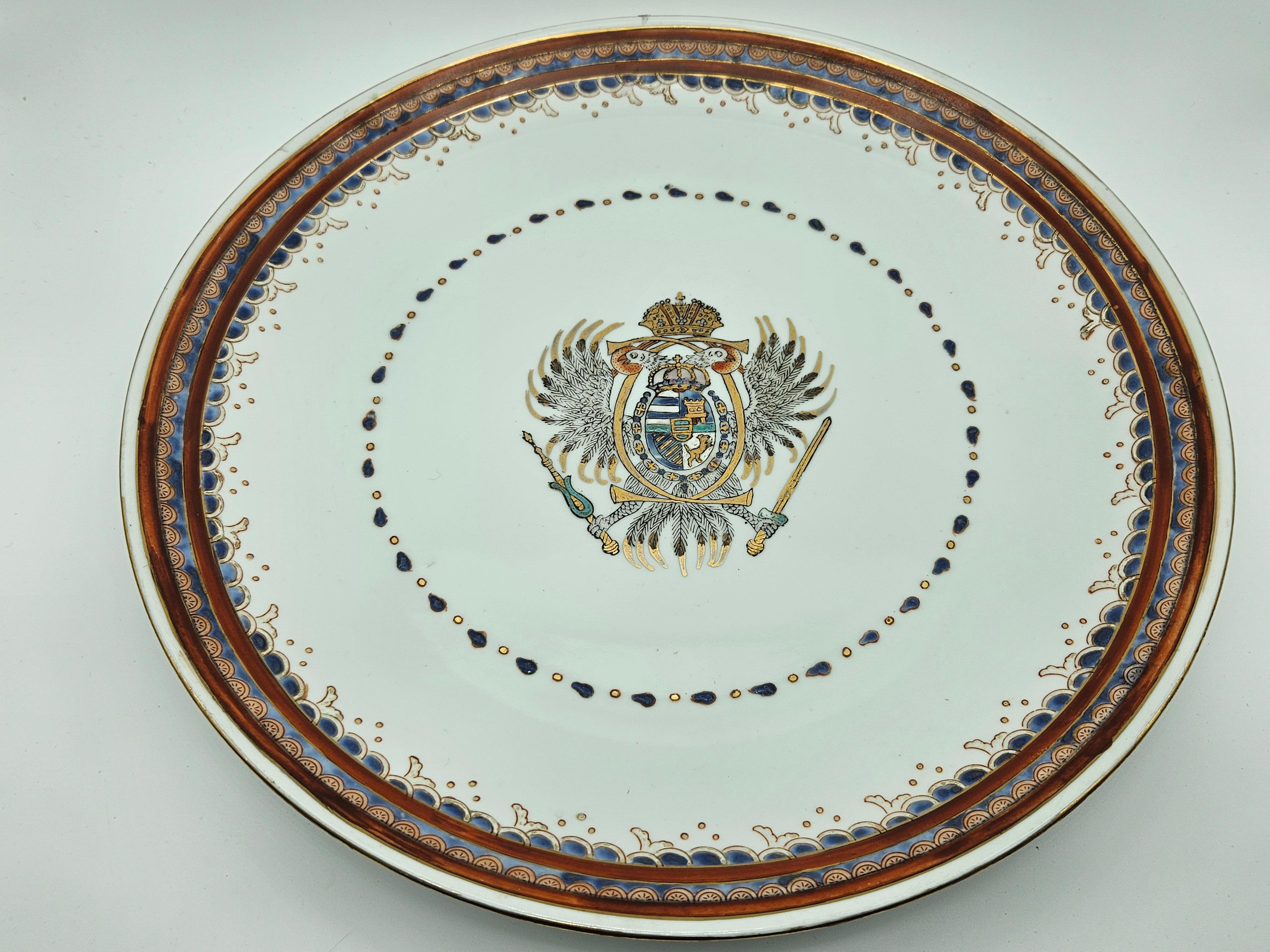 Pair of plates with polychrome decoration and raised rim.
Early 20th century European production.

They show normal signs of wear due to age and use.