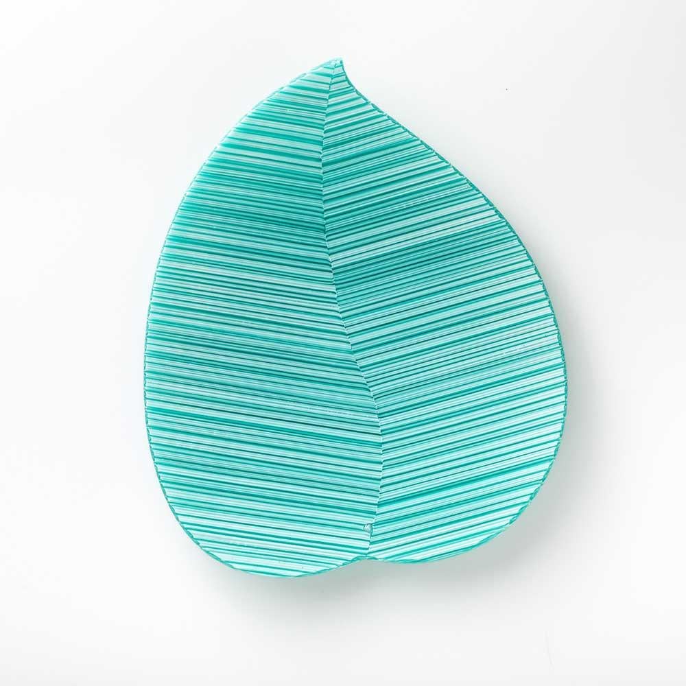 La forma della foglia si declina con eleganza in questo piatto di design realizzato giustapponendo di traverso frammenti di canne di vetro murrino millefiori, e poi fuso al calore del forno. La murrina con la lettera M è il simbolo dell’originalità