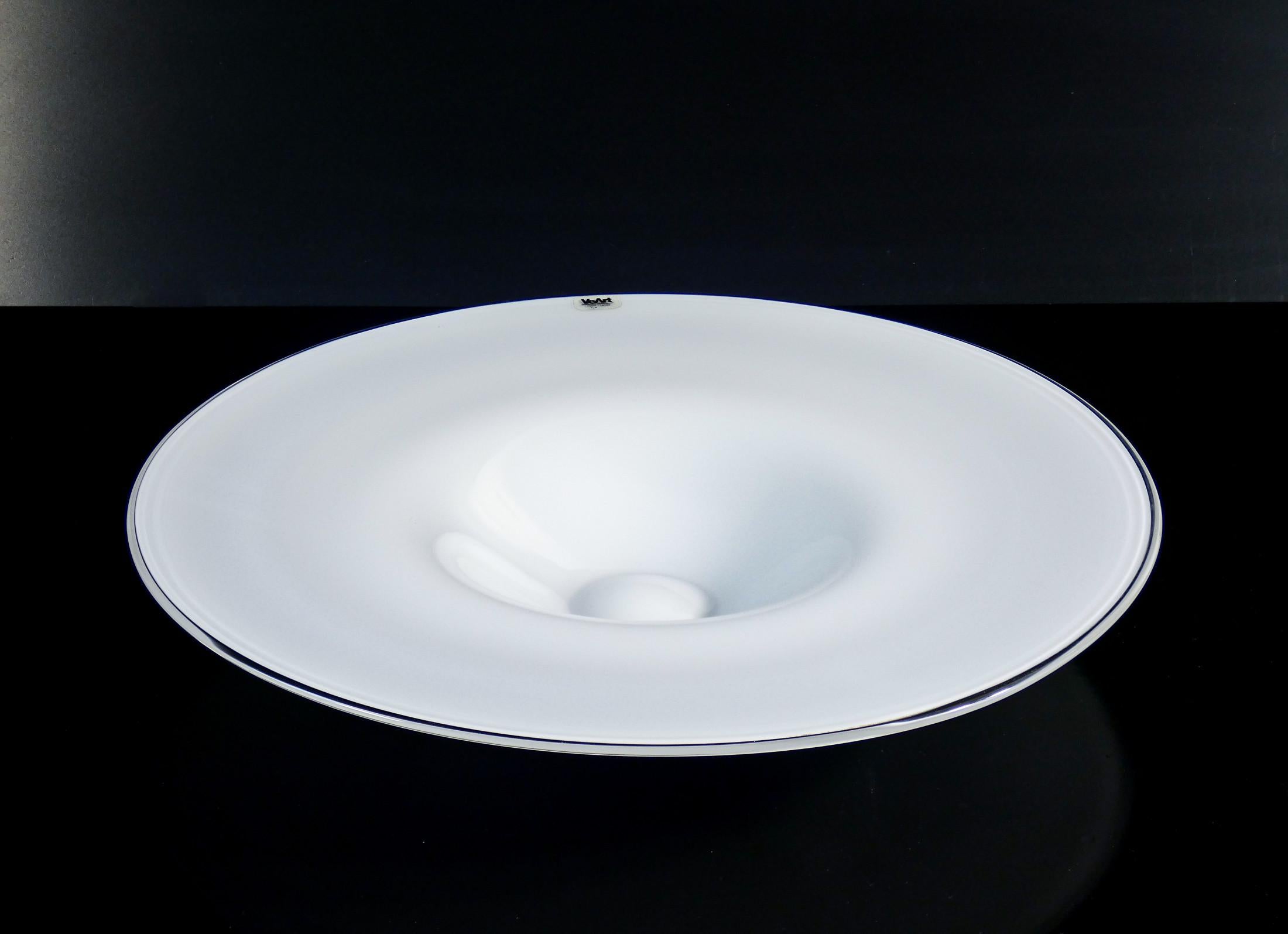 Piatto centrotavola
design VEART,
in vetro soffiato.

ORIGINE
Murano, Venezia

PERIODO
Anni 90

MARCA
VaArt

MATERIALI
Vetro soffiato bianco

DIMENSIONI
Ø 42.5 cm
H 6.5 cm

CONDIZIONI
Il piatto è in perfette condizioni, come è possibile constatare