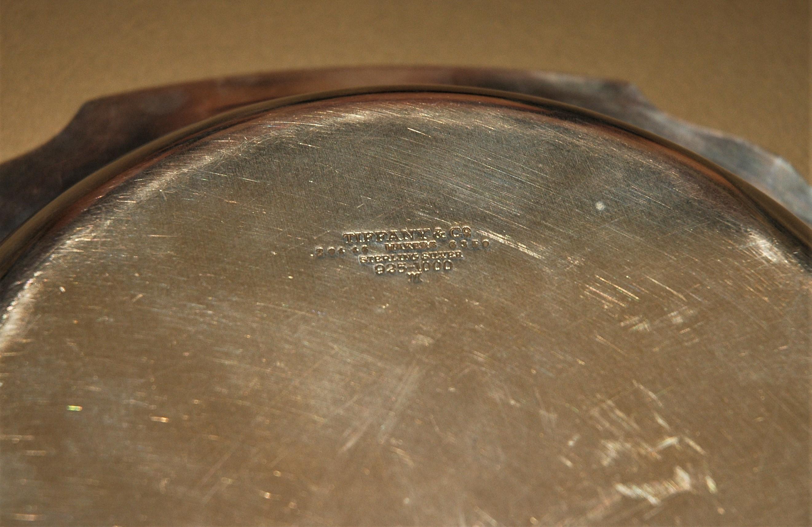 Tiffany & Co. signed silver centerpiece plate. Floral decorations on the border. Three initials are engraved on the bottom: L H B.
Period of realization: 1907-1938