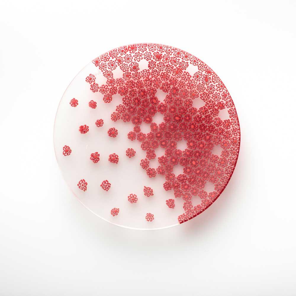 Der Frühlingswind zeichnet Lichtspiele auf die Murrine der Platte, wie eine sanfte Brise. Der von dem Designer Paolo Cappello entworfene Teller verwendet die Millefiori-Murrine-Glas-Technik, bei der Glasstäbchen mit einem kleinen Muster kombiniert