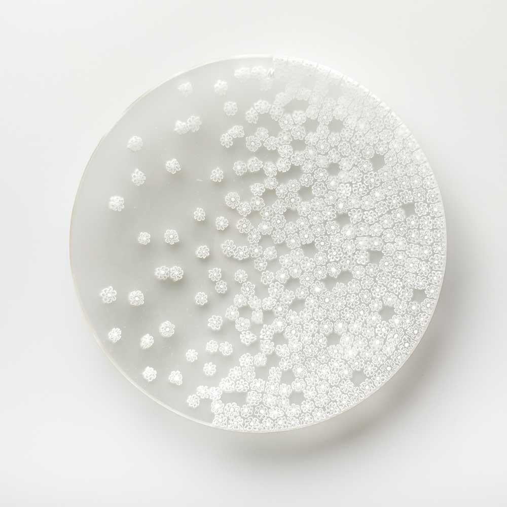 Il vento primaverile dispone le murrine sul piatto come se stessero danzando. Questo capolavoro del designer Paolo Cappello è realizzato con la tecnica del “vetro murrino millefiori”, che combina pezzi di bacchetta di vetro, ognuno con un piccolo