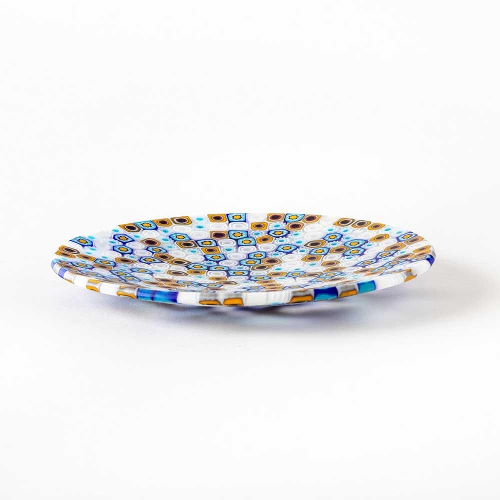 L’unione di design contemporaneo e artigianato artistico caratterizza i piatti Ercole Moretti, rendendoli un lusso raffinato e un’idea regalo speciale. Questo piatto è realizzato a mano con la tecnica chiamata “vetro murrino millefiori” fondendo