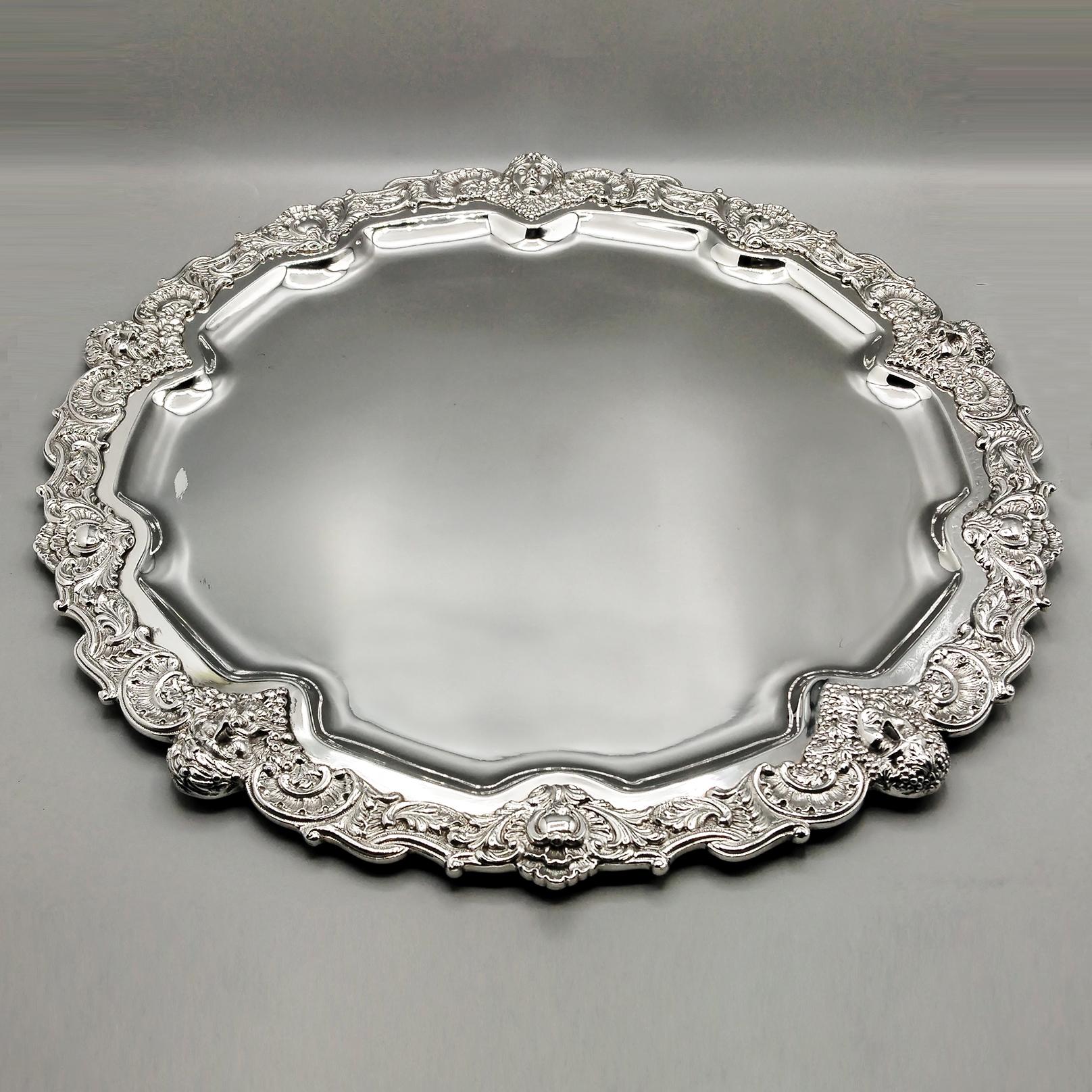 Large Dish/Tray in solid silver 800.
The plate is Baroque in style and made completely by hand. 
On the outside, the slab was hammered and shaped into a very wide flap dive was welded a cast edge, reproducing scrolls and shells, typical of the