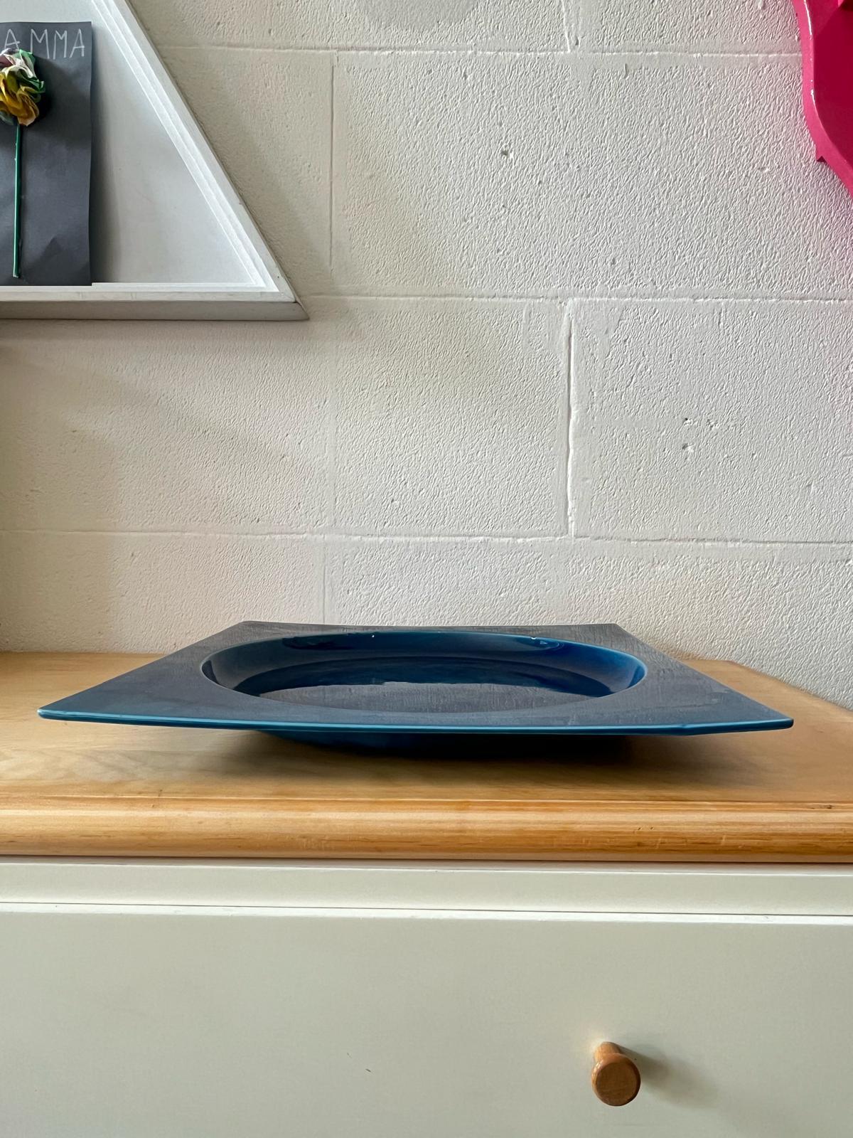 Piatto quadrato in ceramica smaltata blu, Italia, 1970s
Piatto in ceramica dalla forma quadrata, caratterizzato da una smaltatura blu intensa e uniforme. Realizzato con cura artigianale, presenta piccole imperfezioni dello smalto, compatibili con