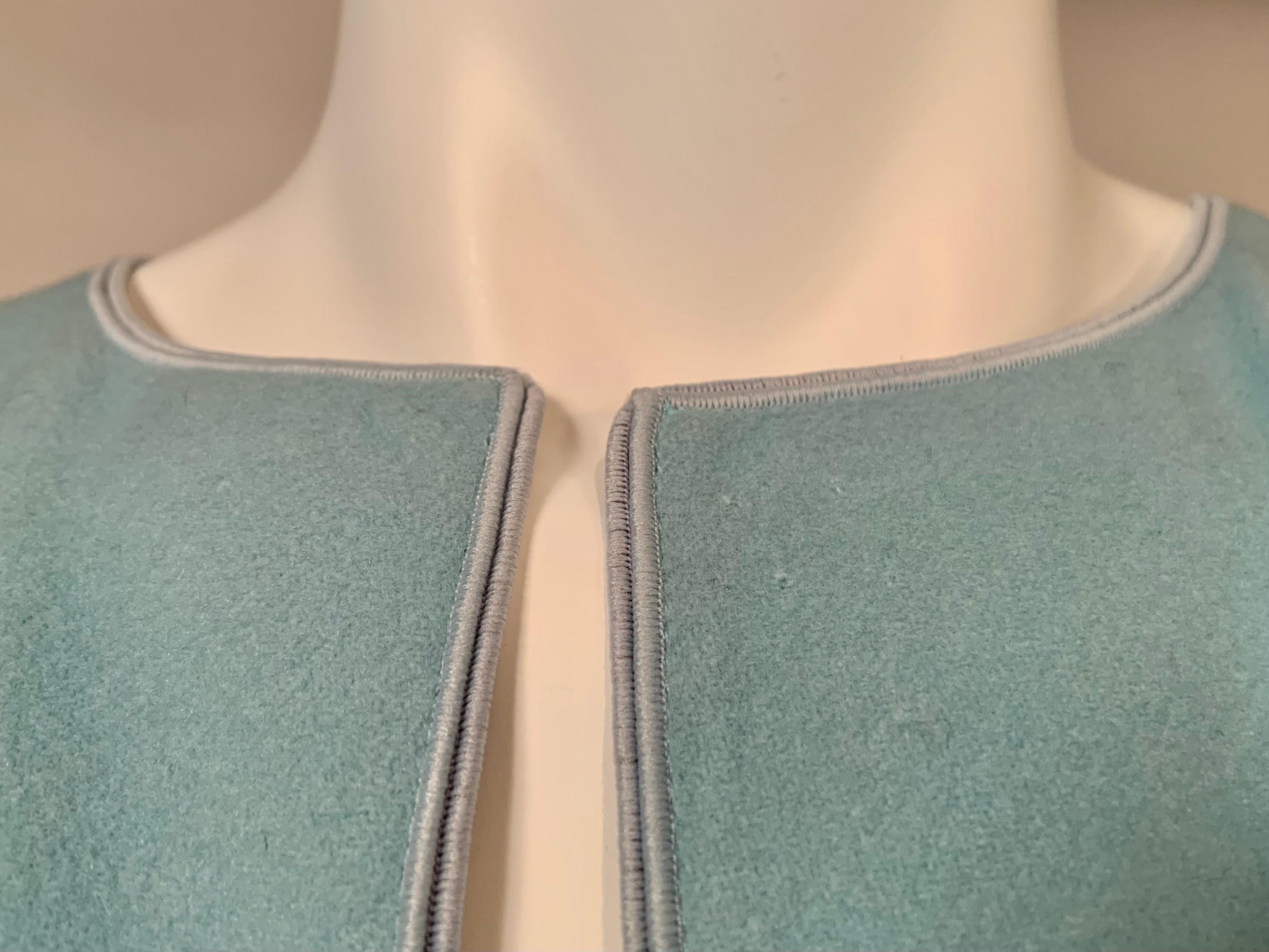 This beautiful Piazza Sempione light blue cashmere blend short cape has never been worn and still bears the original price tag of $950.00.  It is trimmed with a matching blue braid and there are no closures allowing you to drape the piece in a