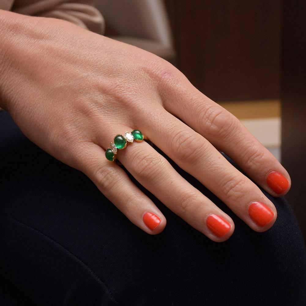 This stunning Picchiotti ring features alternating three oval cabochon emeralds and two white diamond marquis. The ring is handset in an 18 karat yellow gold mounting. There is a total of 3.00 carats of emeralds, and .74 carats of diamonds.