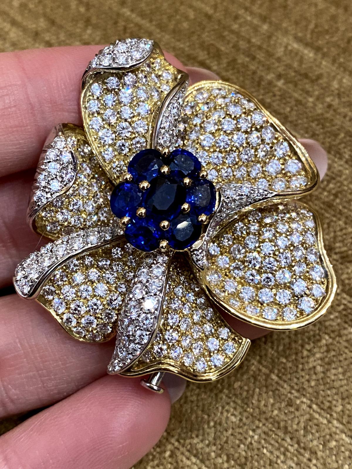 Picchiotti Sapphire and Diamond Flower Brooch in 18k Yellow Gold 

Diamond and Sapphire Brooch by PICCHIOTTI features fine quality Oval Blue Sapphires and Round Diamonds set in 18k Yellow Gold that come together to form a flower design. The brooch
