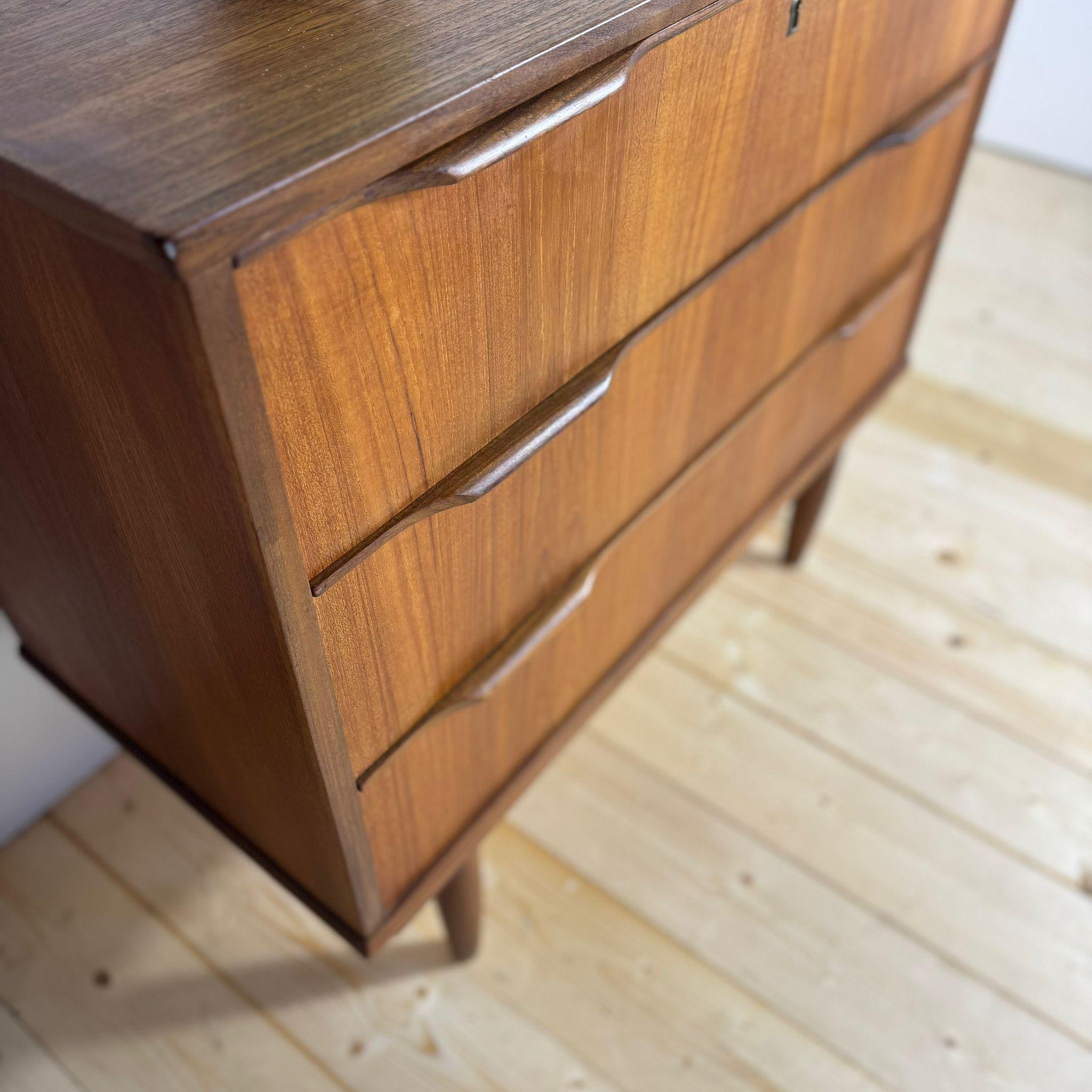 Questa piccola cassettiera danese degli anni Sessanta rappresenta alla perfezione l'essenzialità e la raffinatezza del design Mid-Century scandinavo. Realizzata in teak impiallacciato, mette in risalto le sue venature calde e regolari, conferendo al