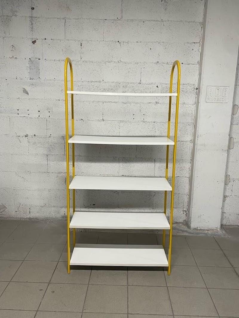 Piccola libreria anni '80 con struttura in tubolare di metallo laccato giallo e 5 ripiani in laminato bianco.

Facilmente collocabile in tutti gli ambienti della casa.
