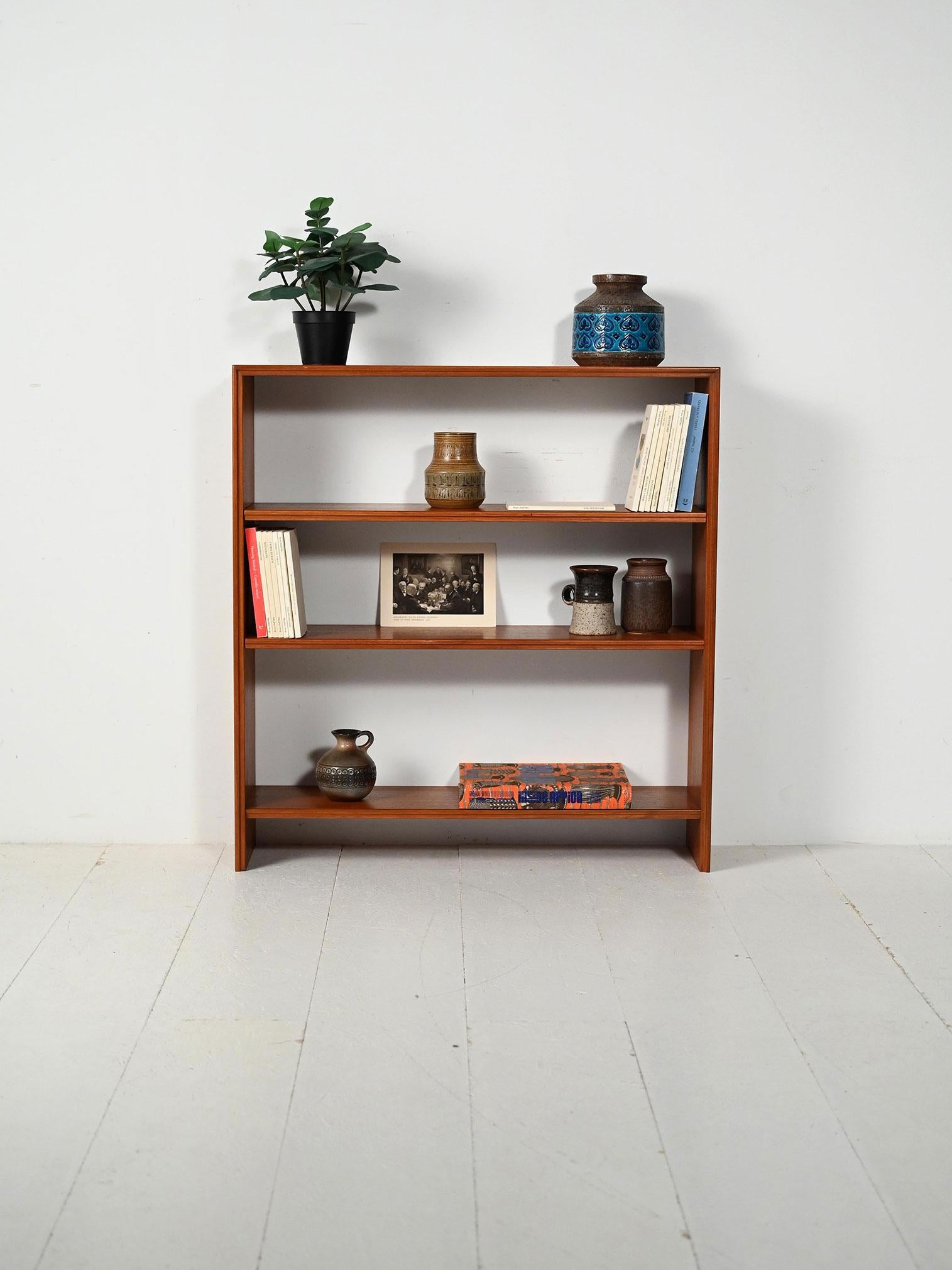 Bibliothèque scandinave en teck, avec trois panneaux régolabilisés en vue et des lignes minimalistes, production nordique des années 60.

Bibliothèque scandinave des années 60, réalisée en teck, avec trois murs dont deux régalés. Les proportions