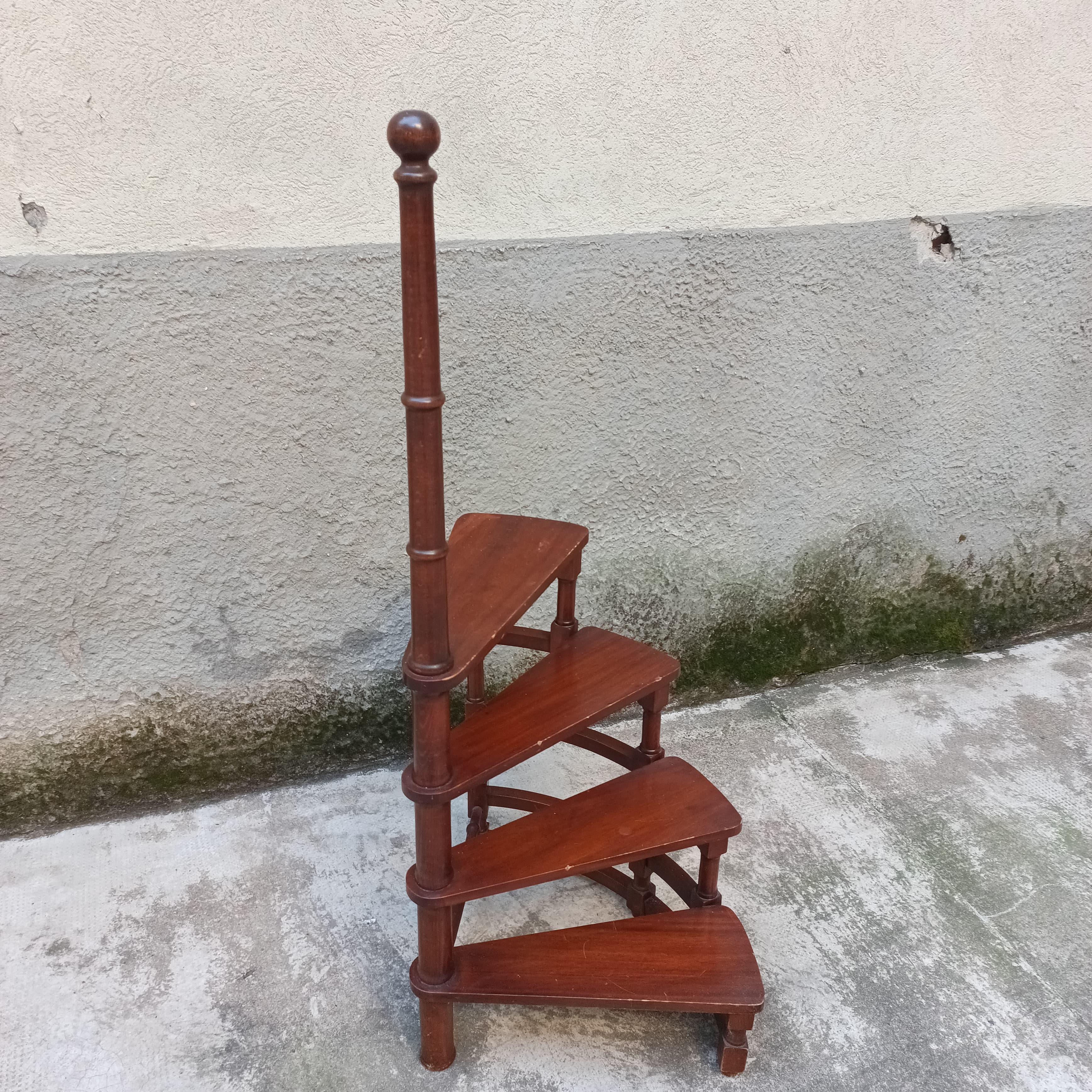 Piccola e discreta scaletta da biblioteca a quattro gradini montati a chiocciola su un asse centrale in legno tornito.
Produzione italiana, anni '60 circa.
Buone condizioni.