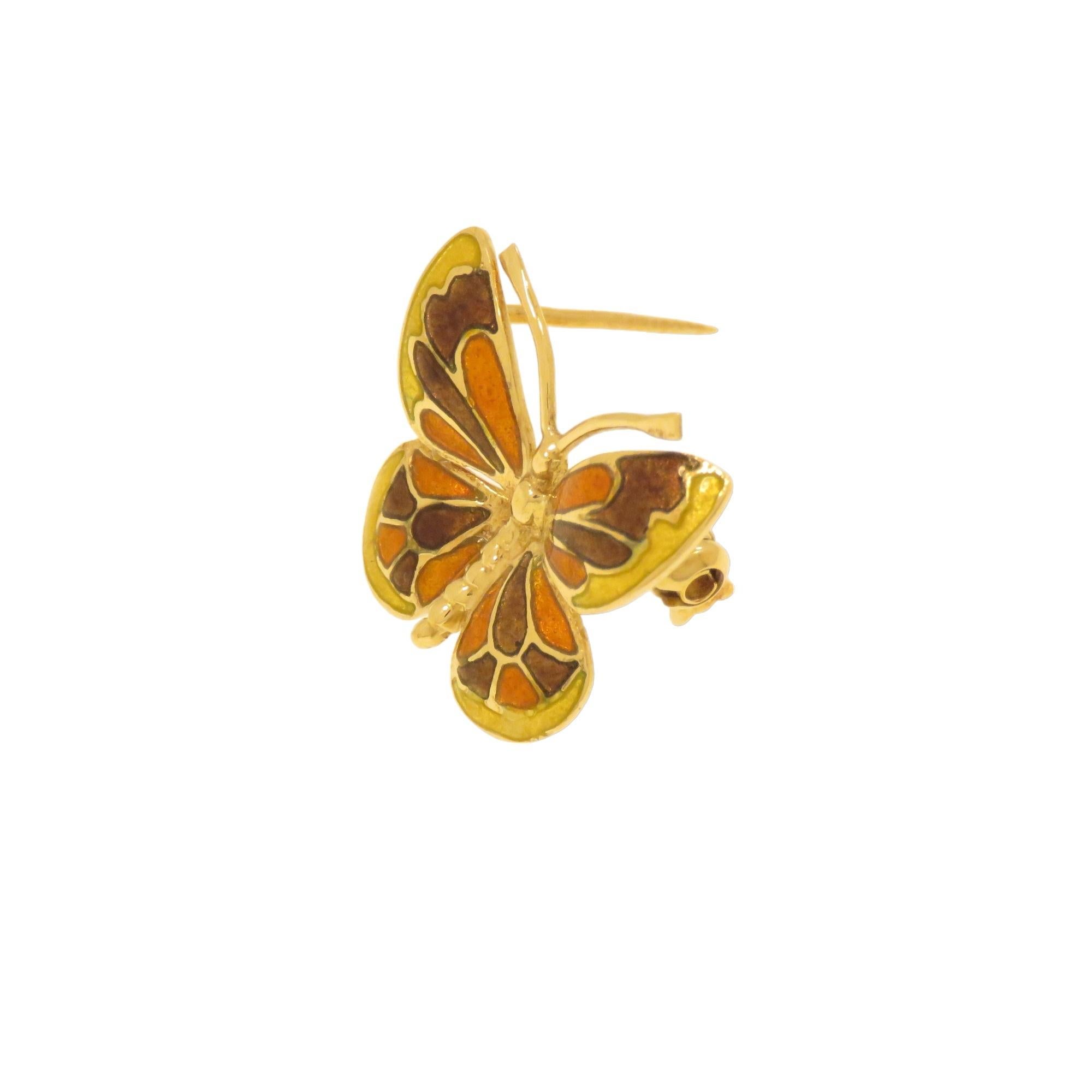 Elegante e graziosa piccola spilla d'epoca a forma di farfalla realizzata in oro giallo 18 carati. Le ali sono smaltate a fuoco in più colori sulle tonalità dal giallo al marrone. Realizzata a mano in Italia nel 1970 circa. Le dimensioni della