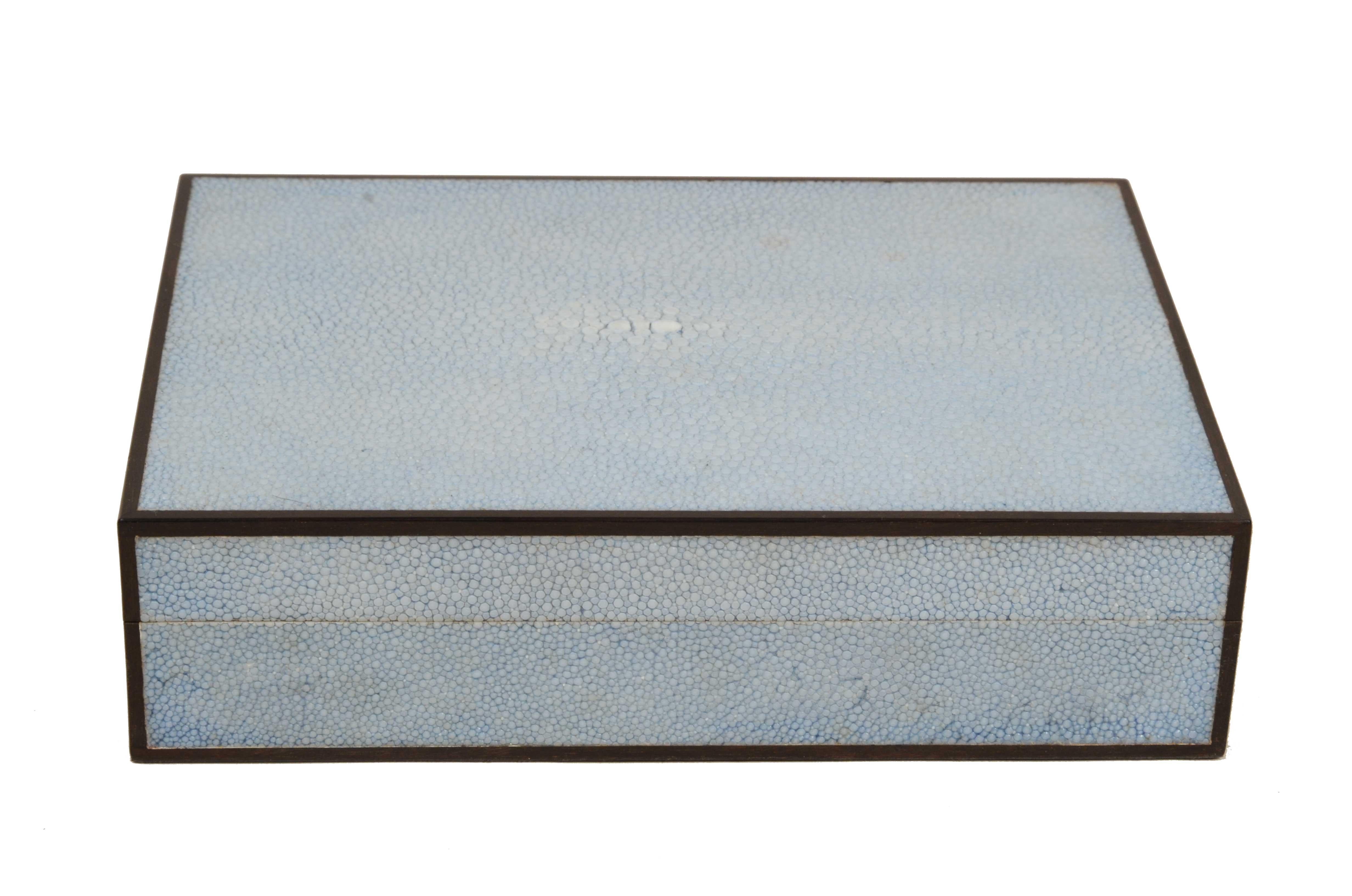 Kleine Zigarrenkiste  aus Teakholz mit Galuchat-Bezug und Seitenprofilen aus Ebenholz, hergestellt in den 1970er Jahren.
Sockel aus Teakholz, meisterhaft furniert mit Galuchat, Pedigree-Leder  hellblaue Farbe mit glänzender Oberfläche und