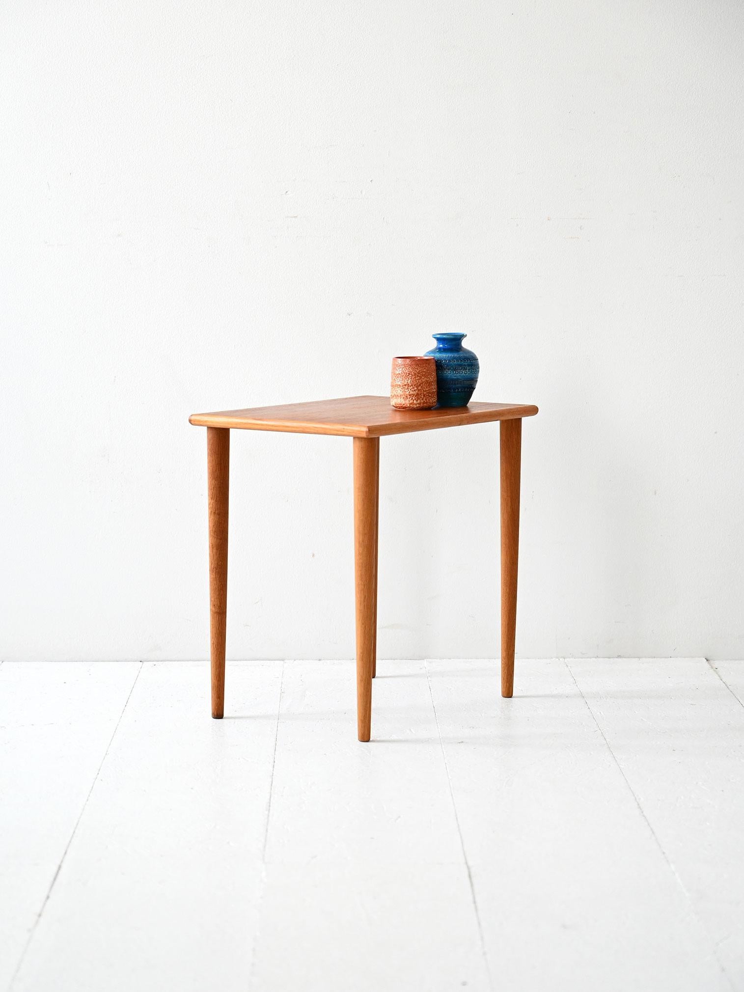 Scandinavian 1950s teak coffee table with tapered turned legs and understated Nordic design.

Scandinavian 1950s coffee table with teak top and solid wood turned legs, tapering downward. The design is essential, balanced, and reflects the functional