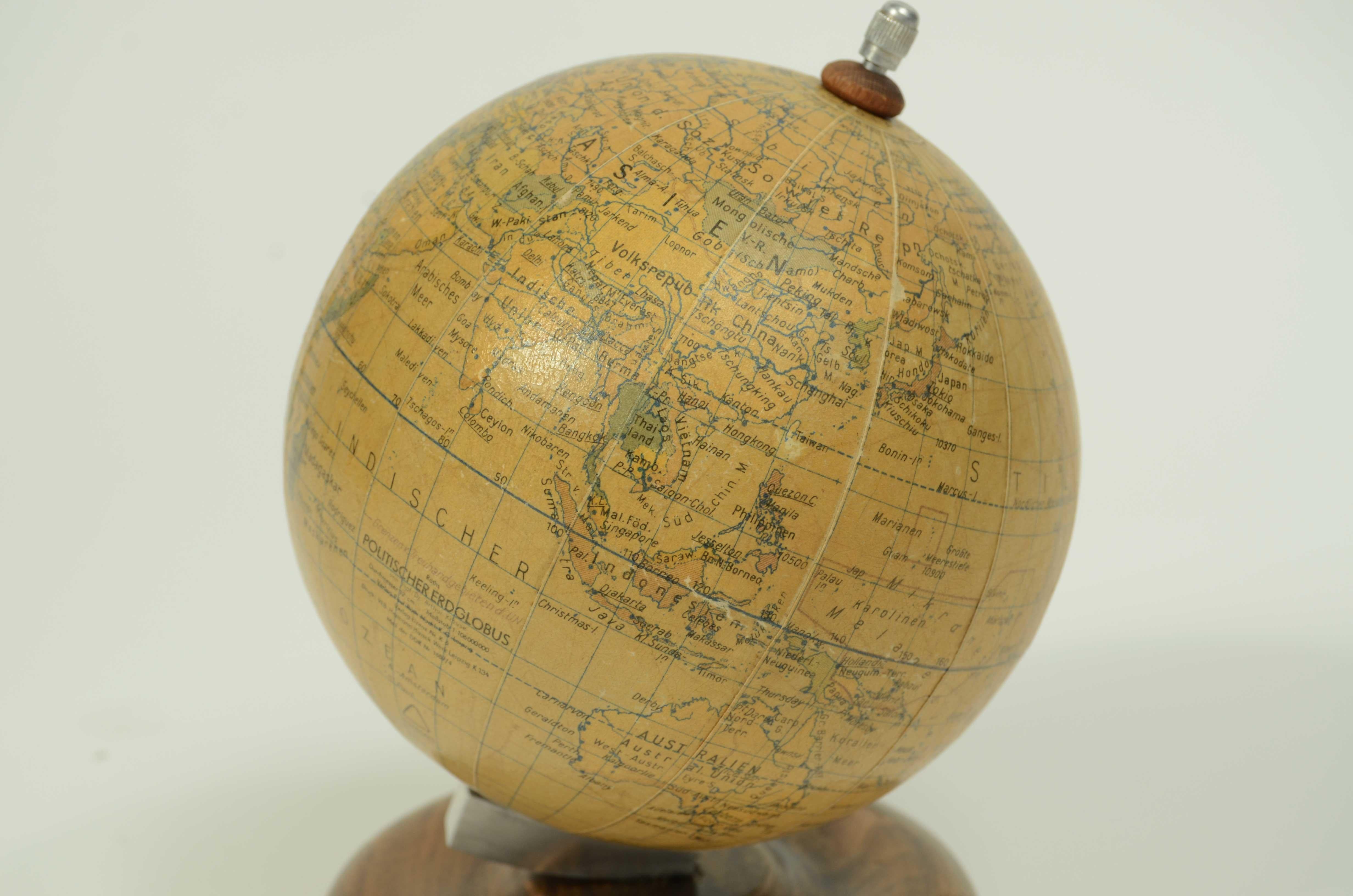 Piccolo globo terrestre edito da Räths Politischer Erdglobus disegnato e delineato dal Prof Arthur Krause negli anni cinquanta. Sfera in cartapesta e base in legno tornito. 
Buono stato qualche segno d’uso.
Misure cm 12x17 – inches 4.7x6.7.