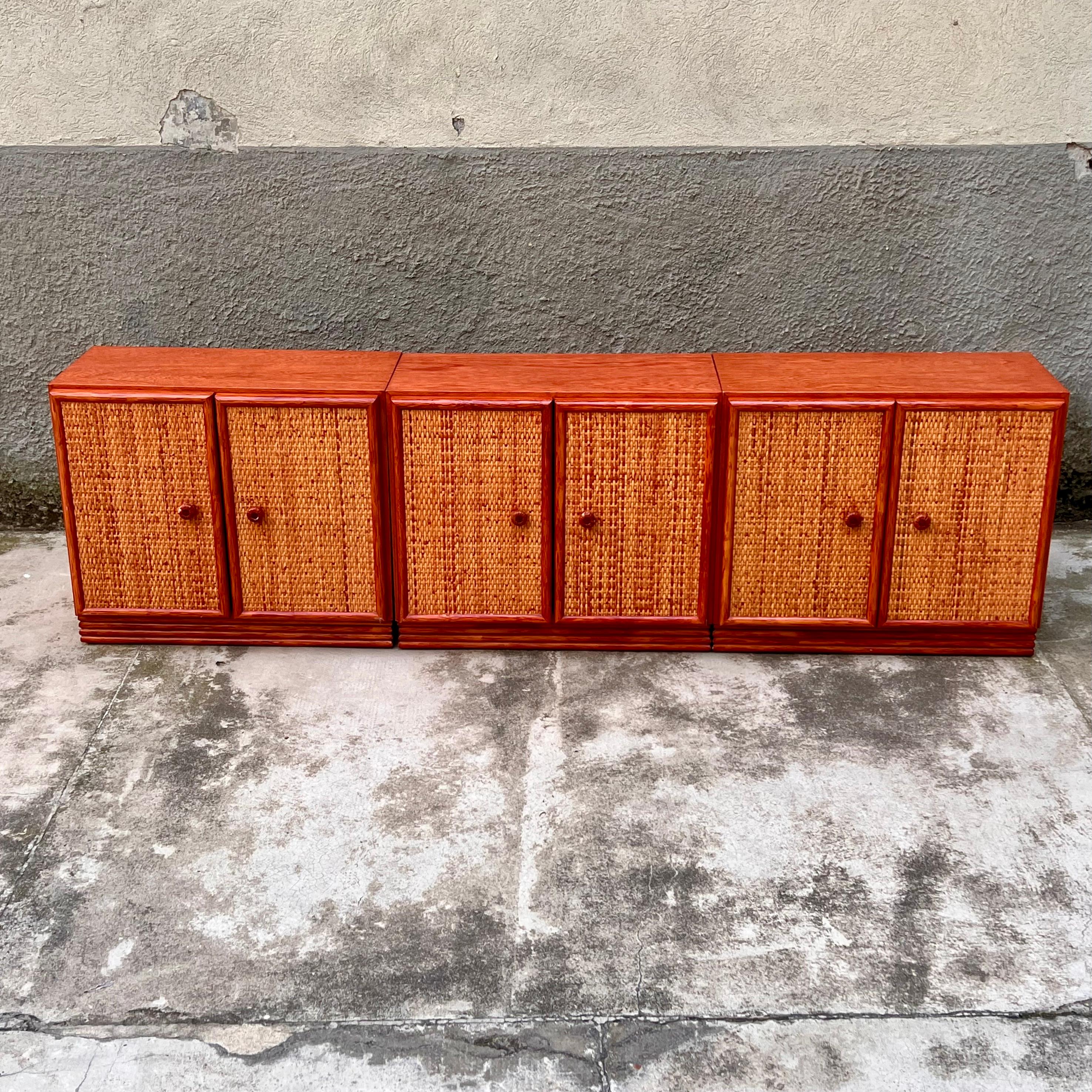 Elegante mobile contenitore degli anni '80, frutto della collaborazione tra le rinomate aziende francesi Maugrion e Roche Bobois. Questo pezzo unico, realizzato in pregiato legno di mogano, si distingue per le ante frontali in vimini intrecciato che