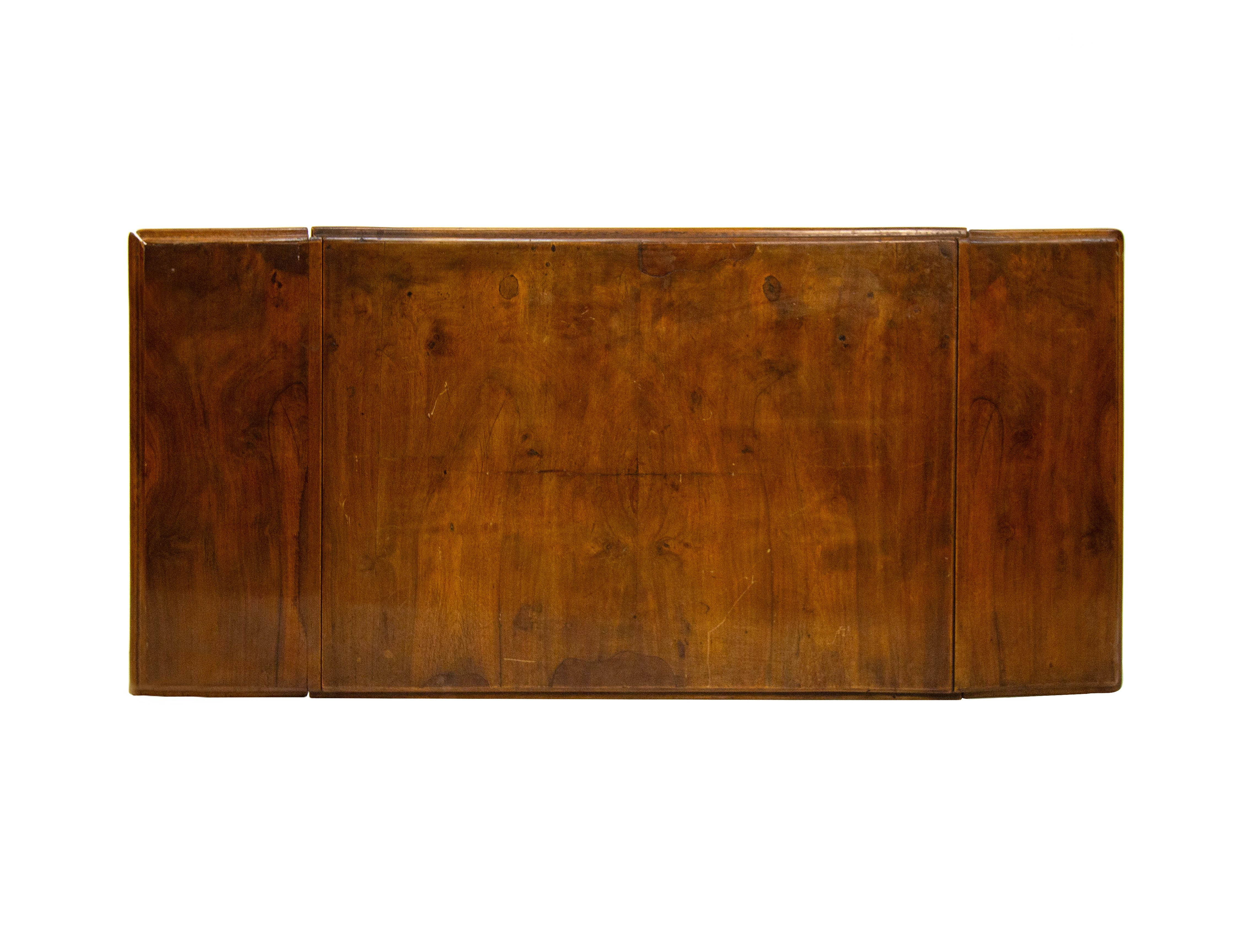 Piccolo scrittoio ad alette in mogano, XIX secolo, piano rettangolare con profilo lievemente modanato, nella cintura un cassetto suddiviso in scomparti e sui lati corti un grembiale a volute centrate da un pinnacolo. Montanti torniti a torchon