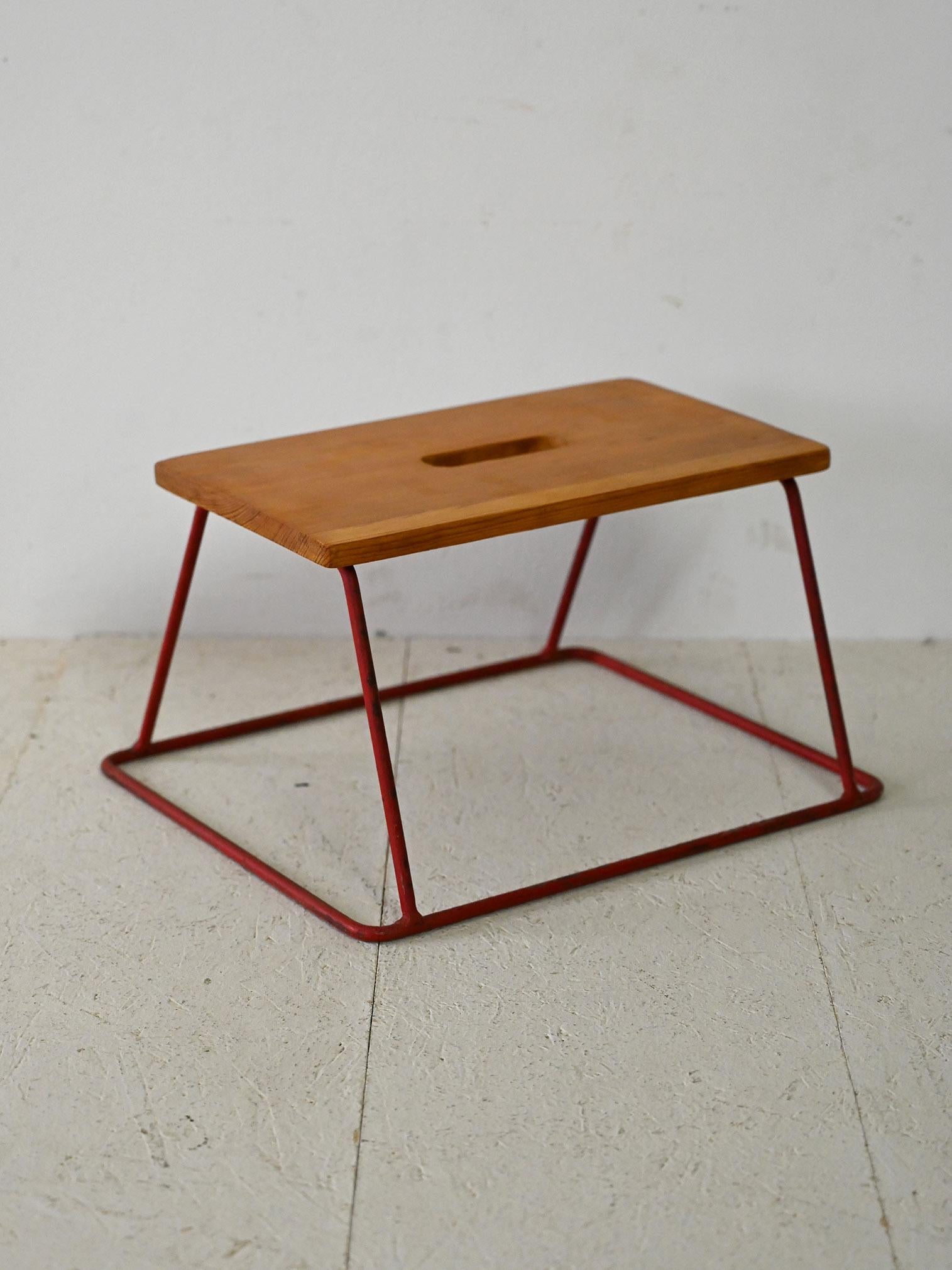 Original Scandinavian stool from the 1960s.

An industrial-flavored piece consisting of a red-painted metal base and a teak seat where there is a hole in the center for easy gripping.
Perfect as a seat for children without sacrificing the aesthetics